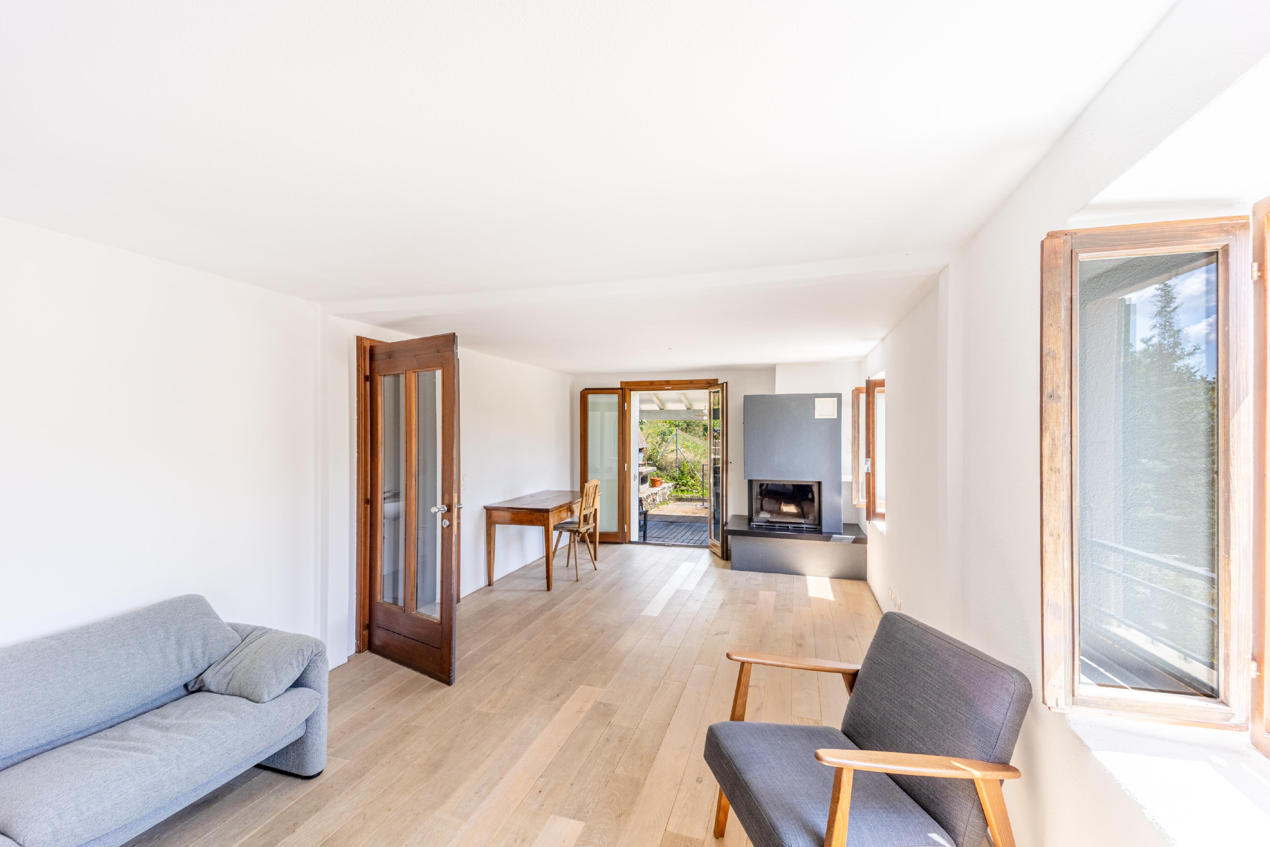 Heller Wohnraum mit Kamin und Holzfenstern