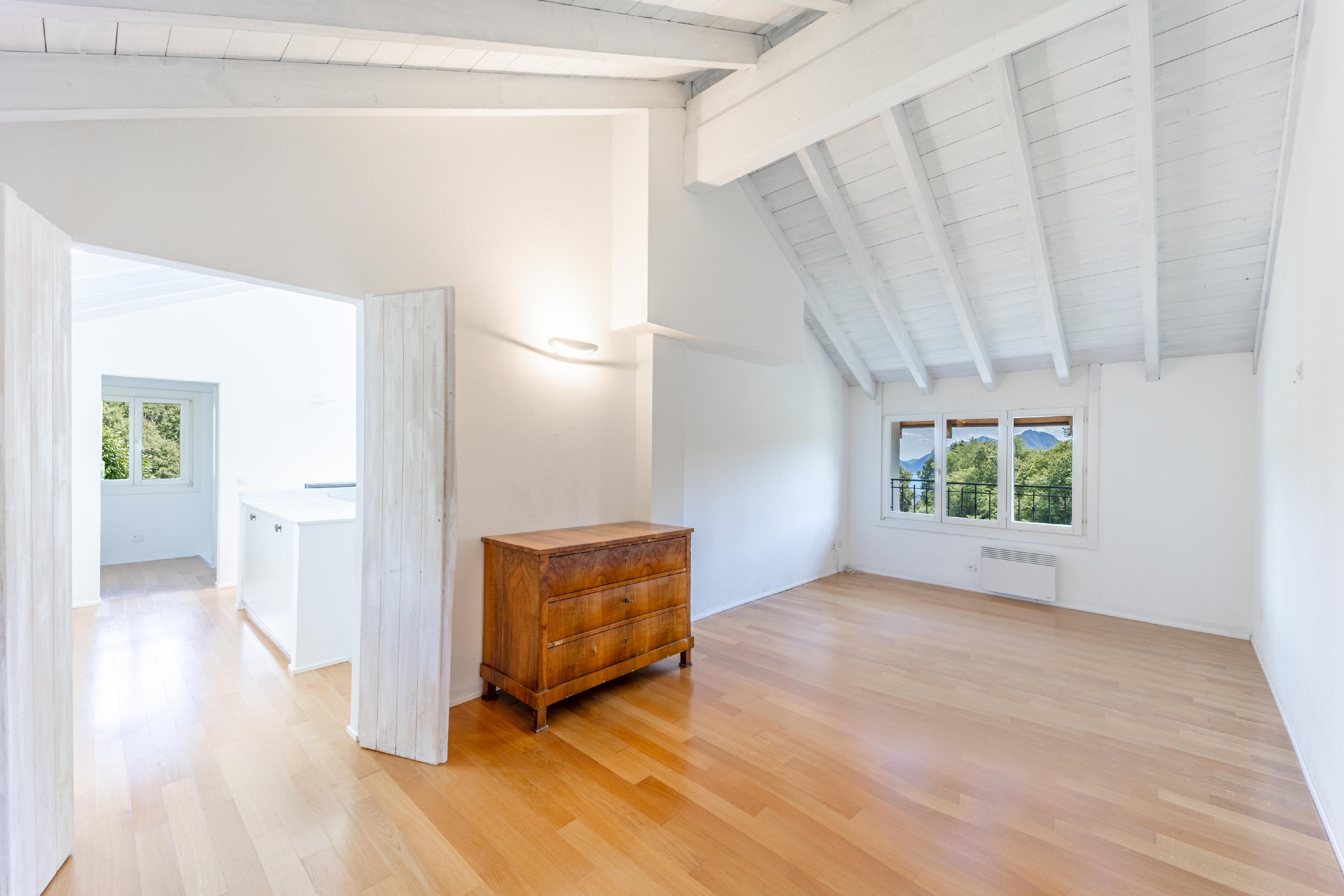 Heller leerer Wohnraum mit Dachschräge und Bergblick