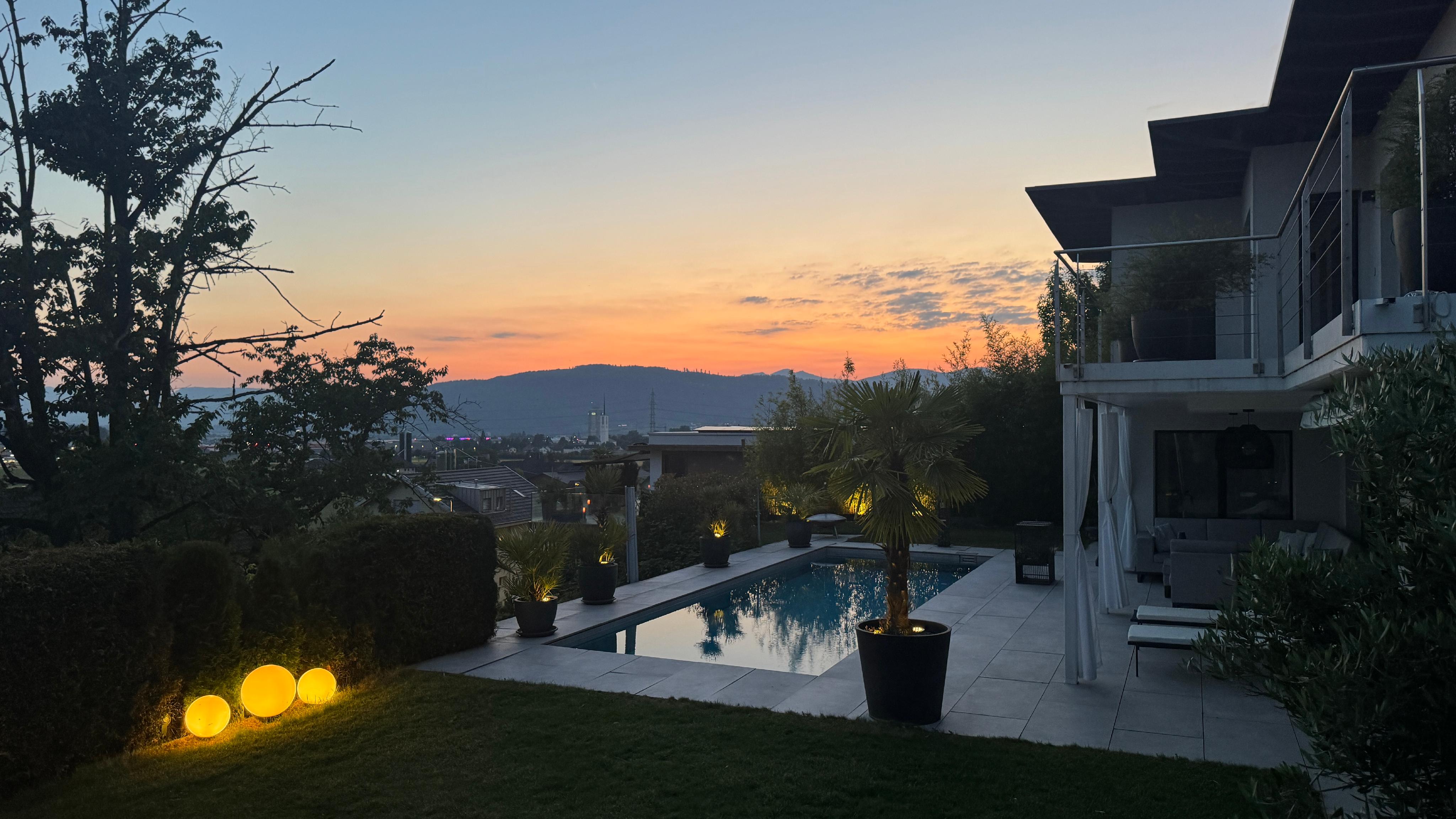 Luxuriöser Außenbereich mit Pool bei Sonnenuntergang