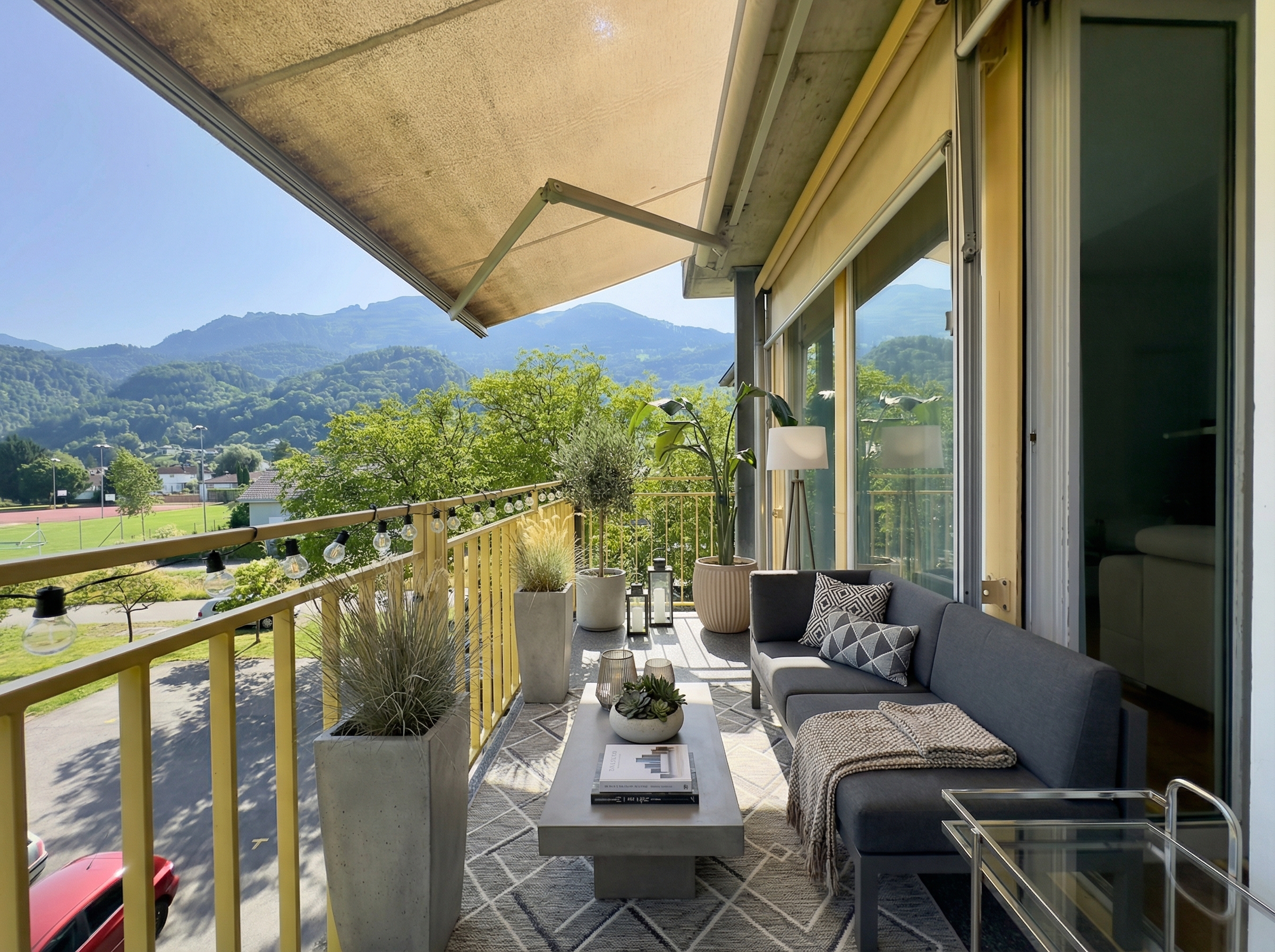 Überdachter Balkon mit Lounge und Bergblick