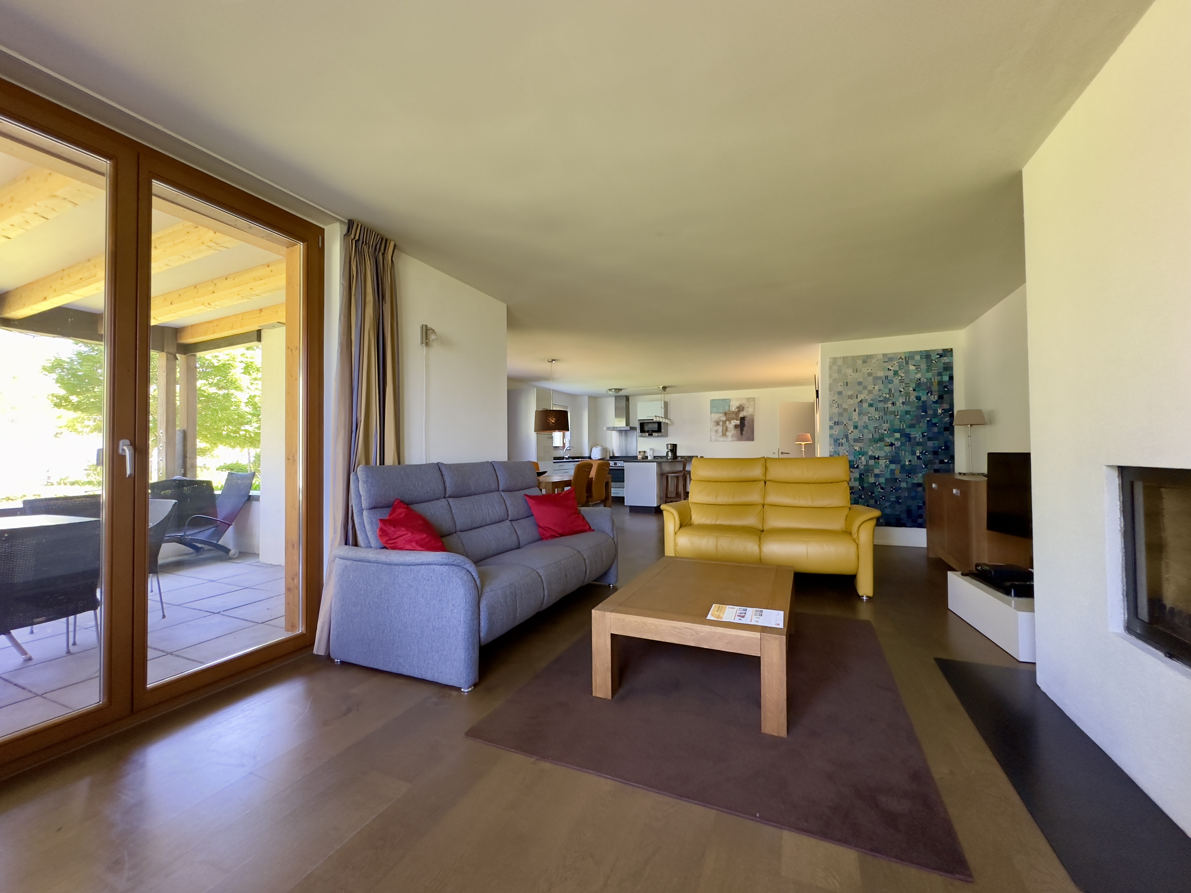 Modernes Wohnzimmer mit offener Küche und Terrasse