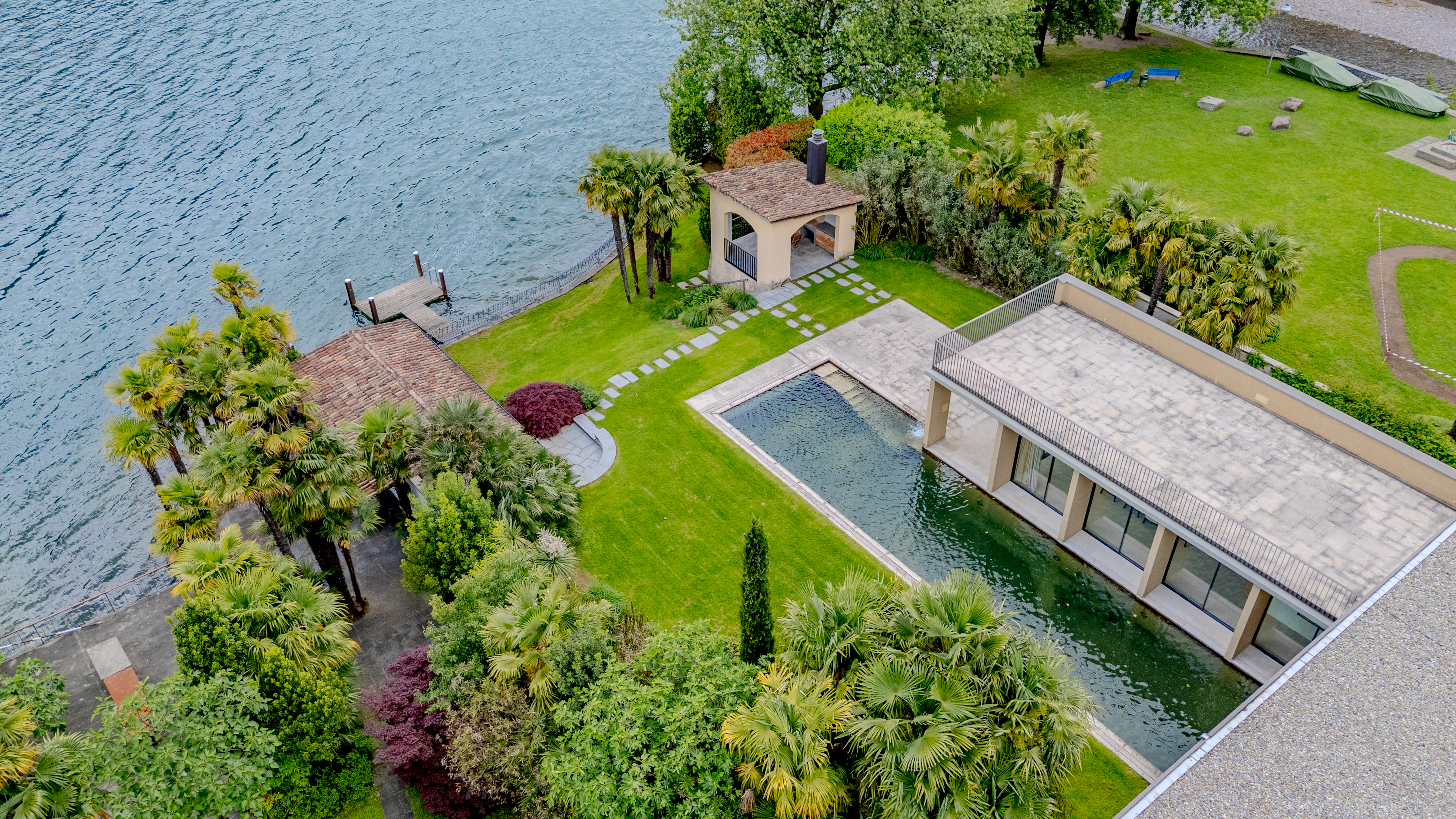 Luftaufnahme einer luxuriösen Uferimmobilie mit Pool und Garten