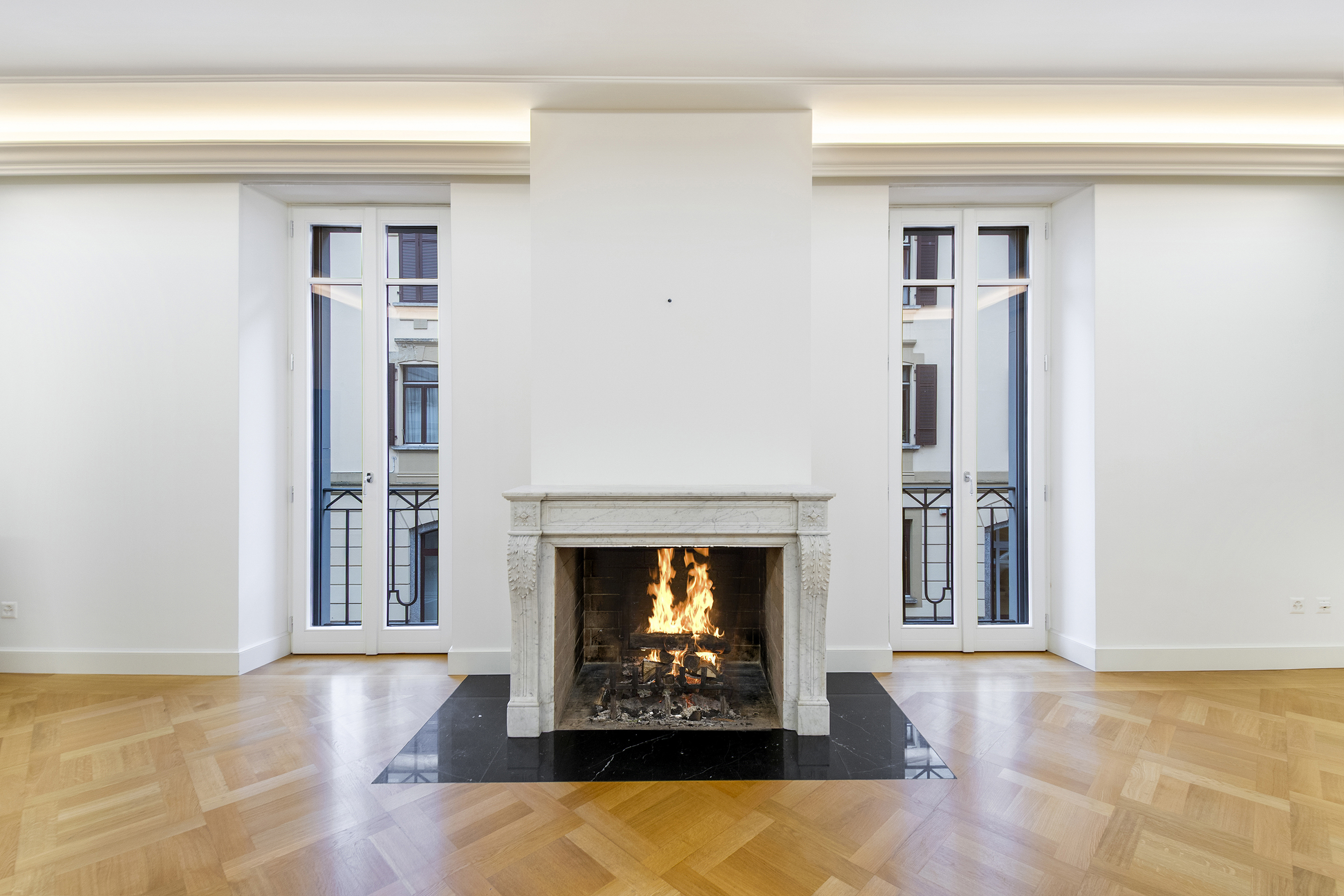 Eleganter Wohnraum mit Kamin und hohen Fenstern