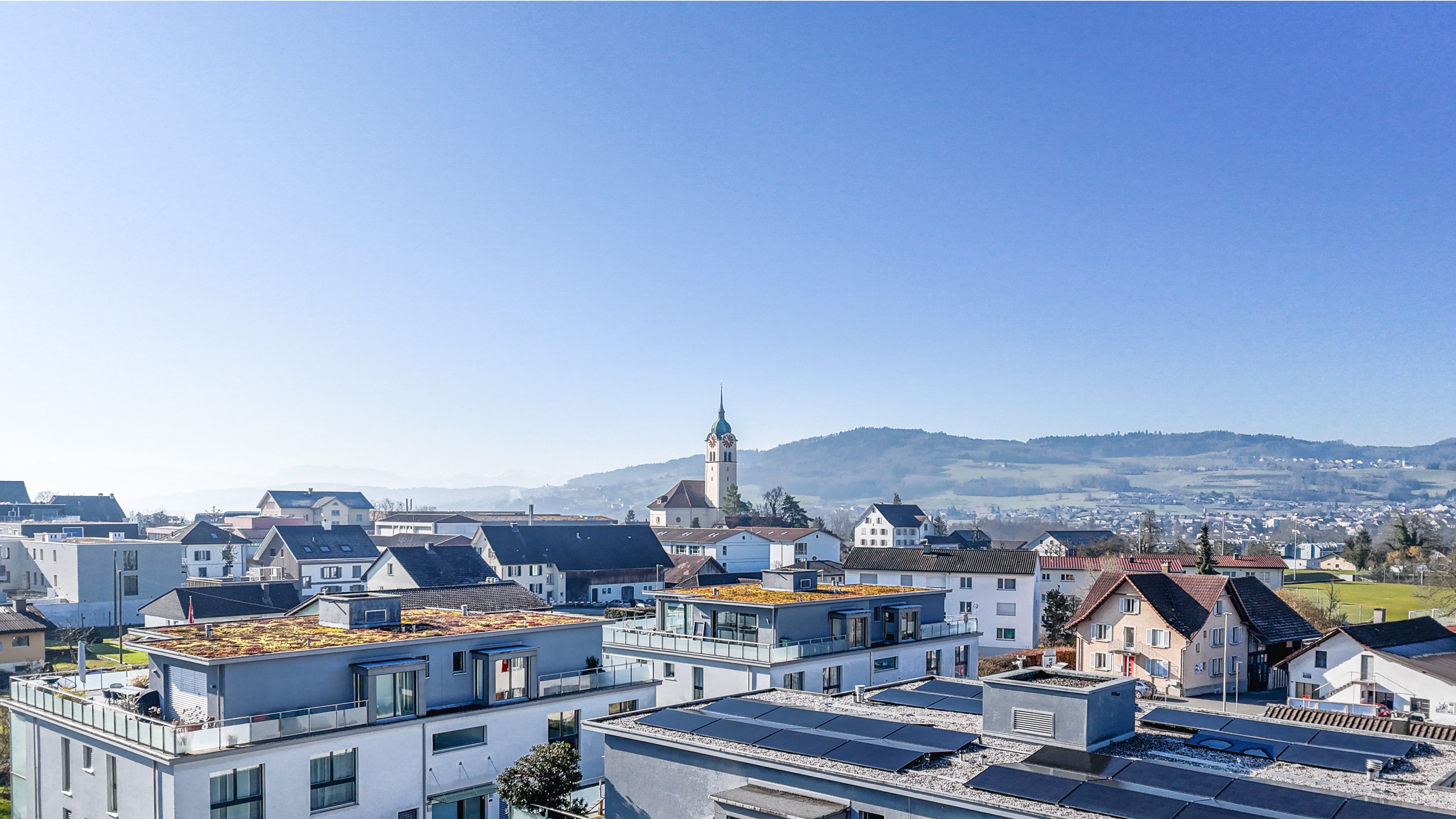 Städtische Wohnsiedlung mit Blick auf Kirche und Hügel