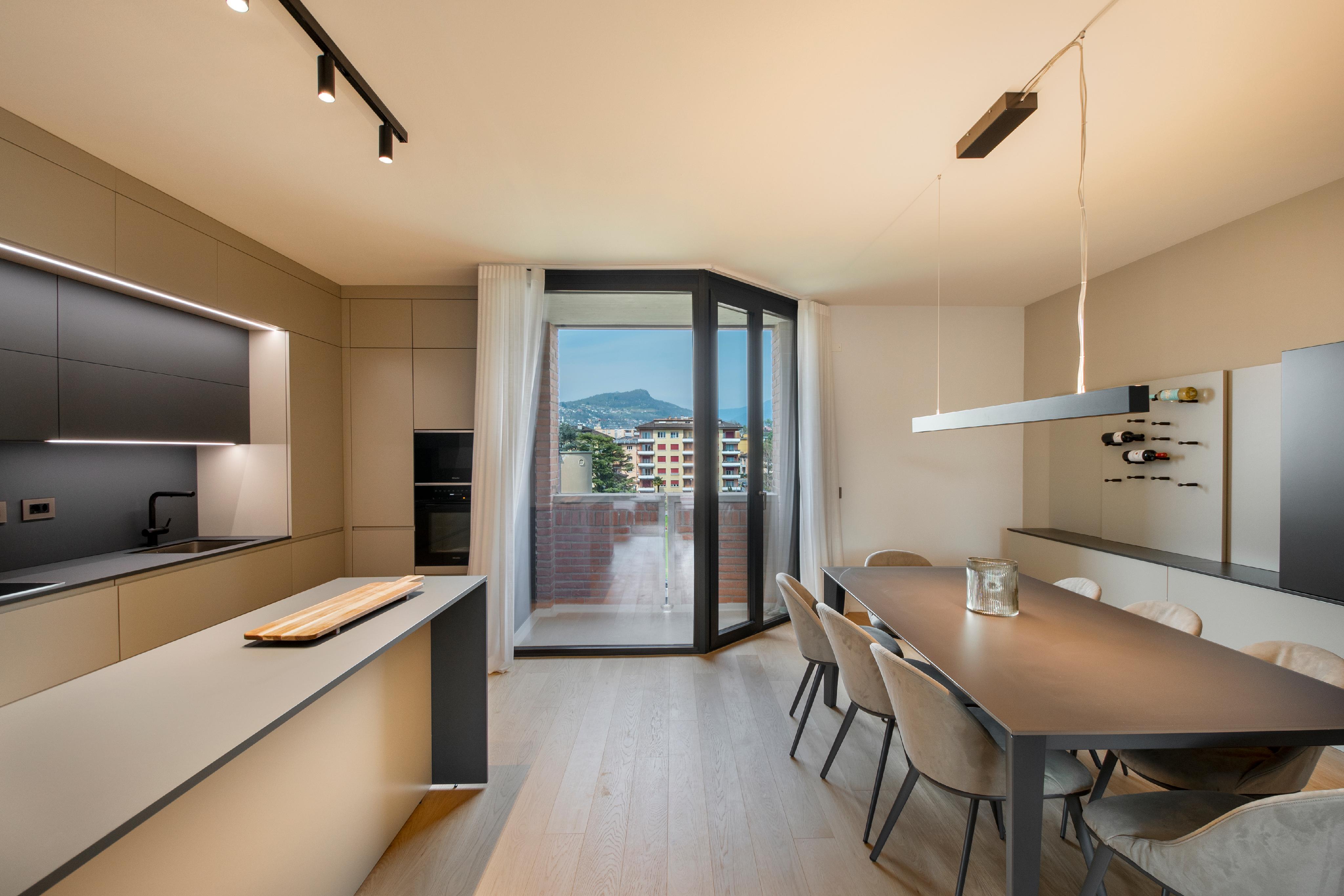 Moderne Küche mit Essbereich und Balkonblick