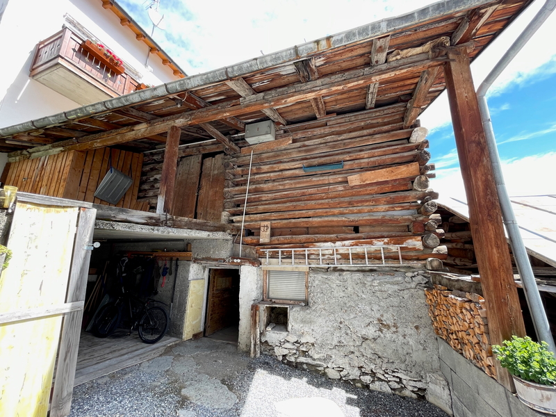 Rustikaler Außenbereich mit Holz- und Putzfassade