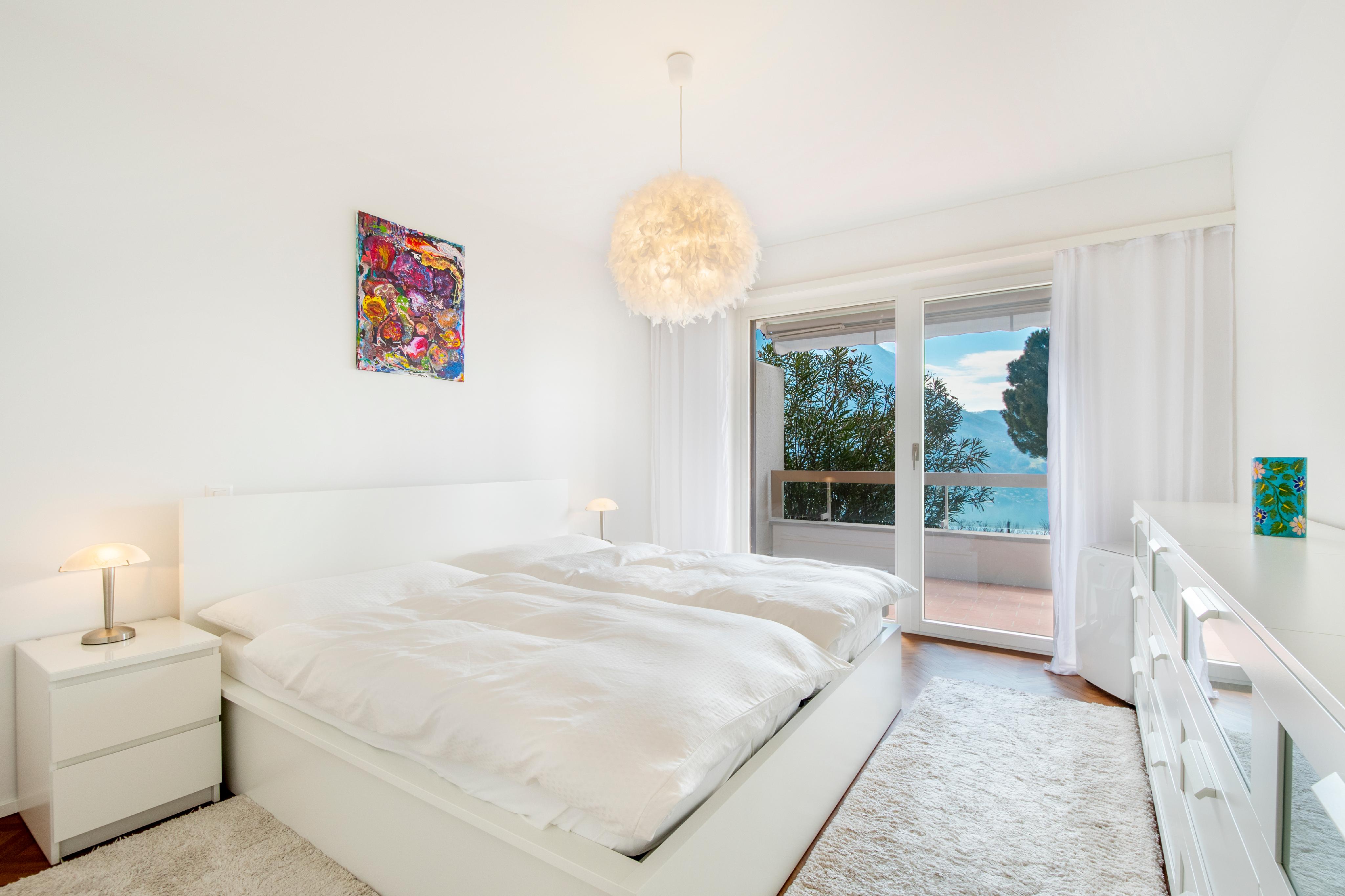 Helles minimalistisches Schlafzimmer mit Balkonblick