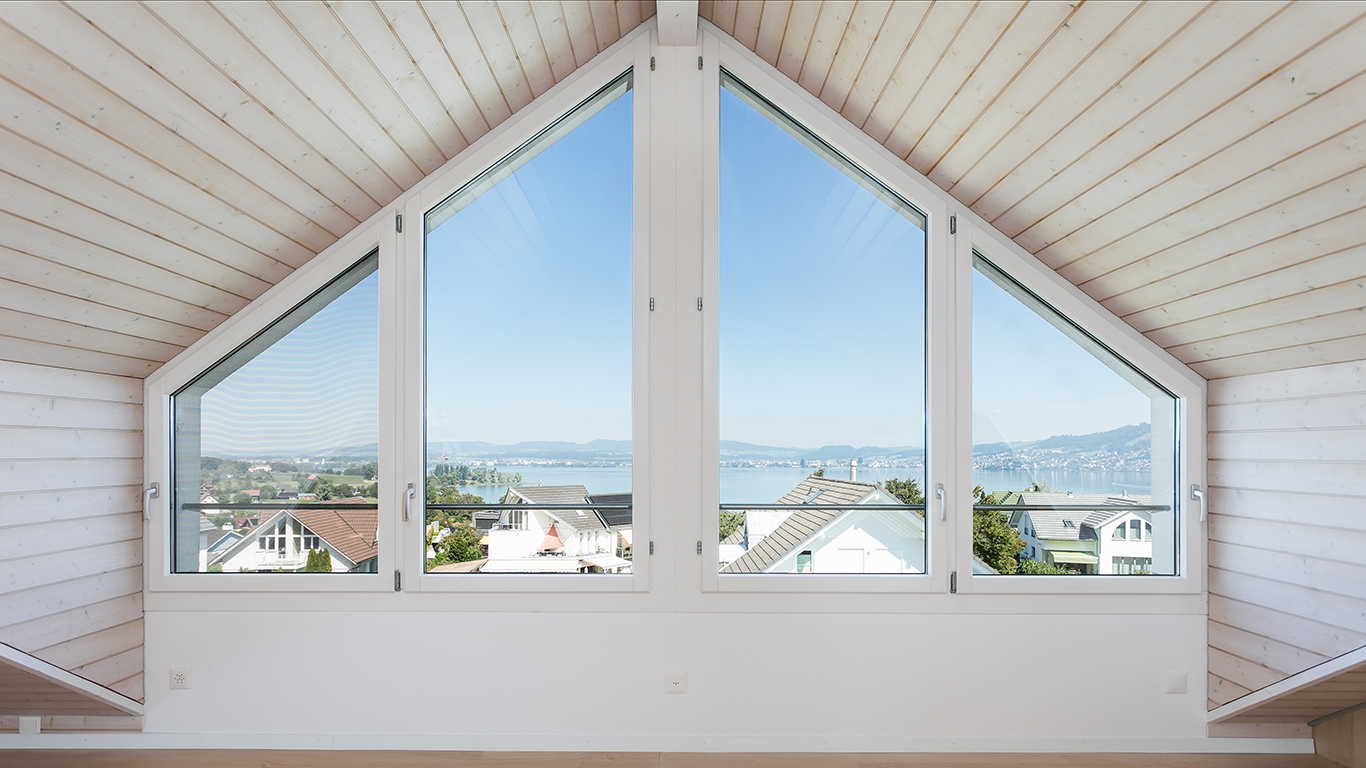 Dachgeschossraum mit Panoramafenstern und Seeblick