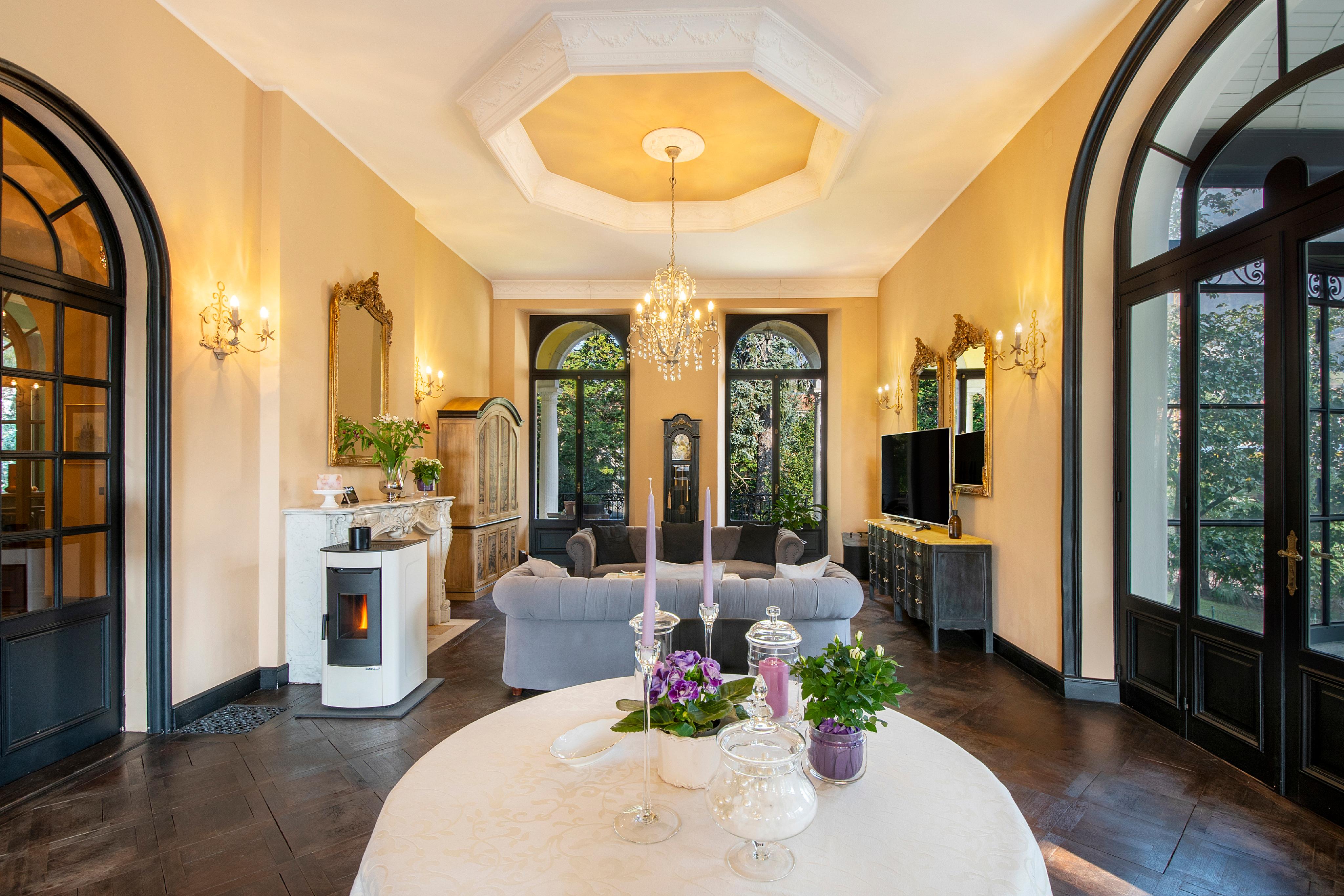 Eleganter Wohnraum mit hohen Fenstern und Kronleuchter