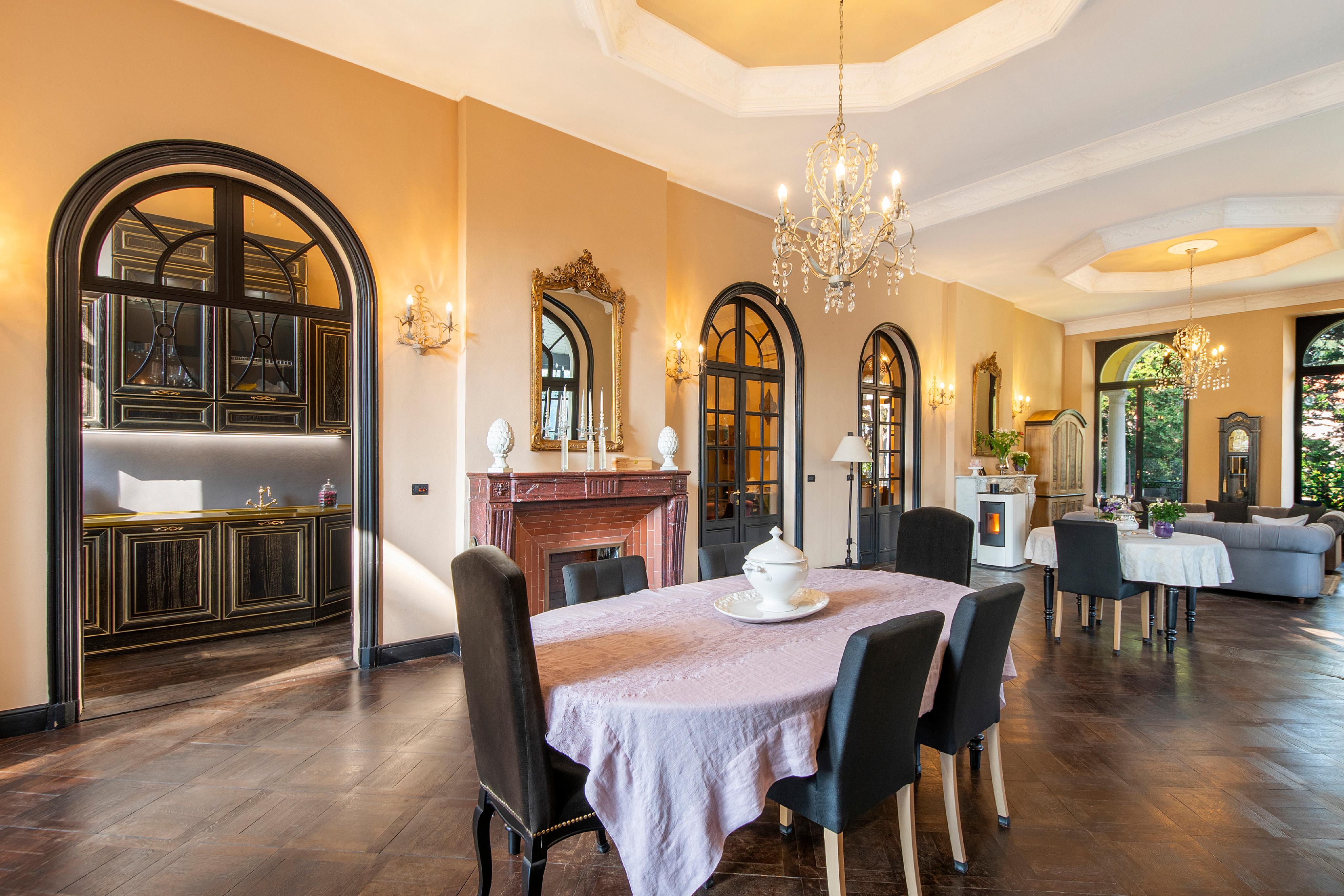 Elegantes Esszimmer mit Kamin und Rundbogenfenstern