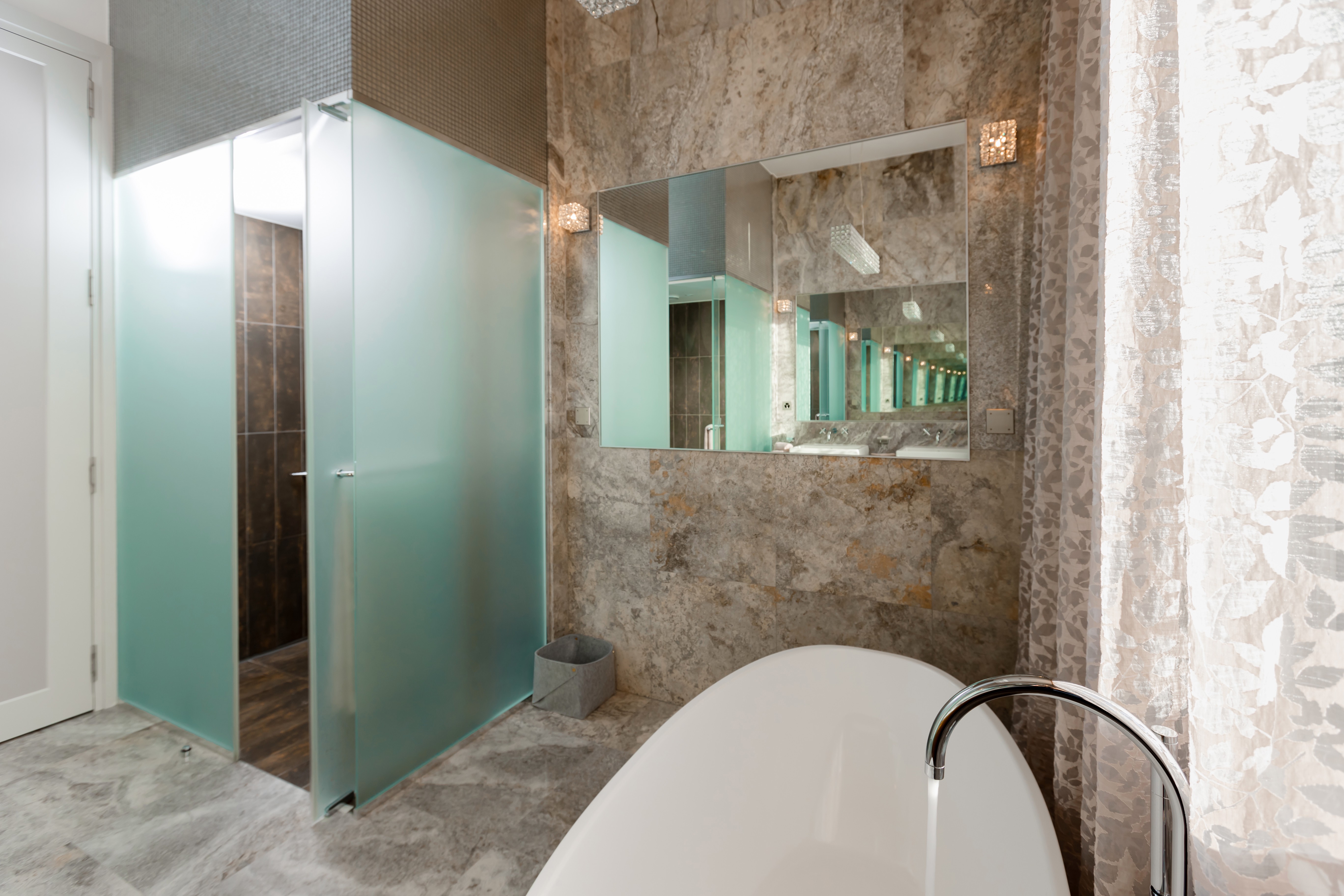 Luxuriöses Badezimmer mit Badewanne und Glasdusche