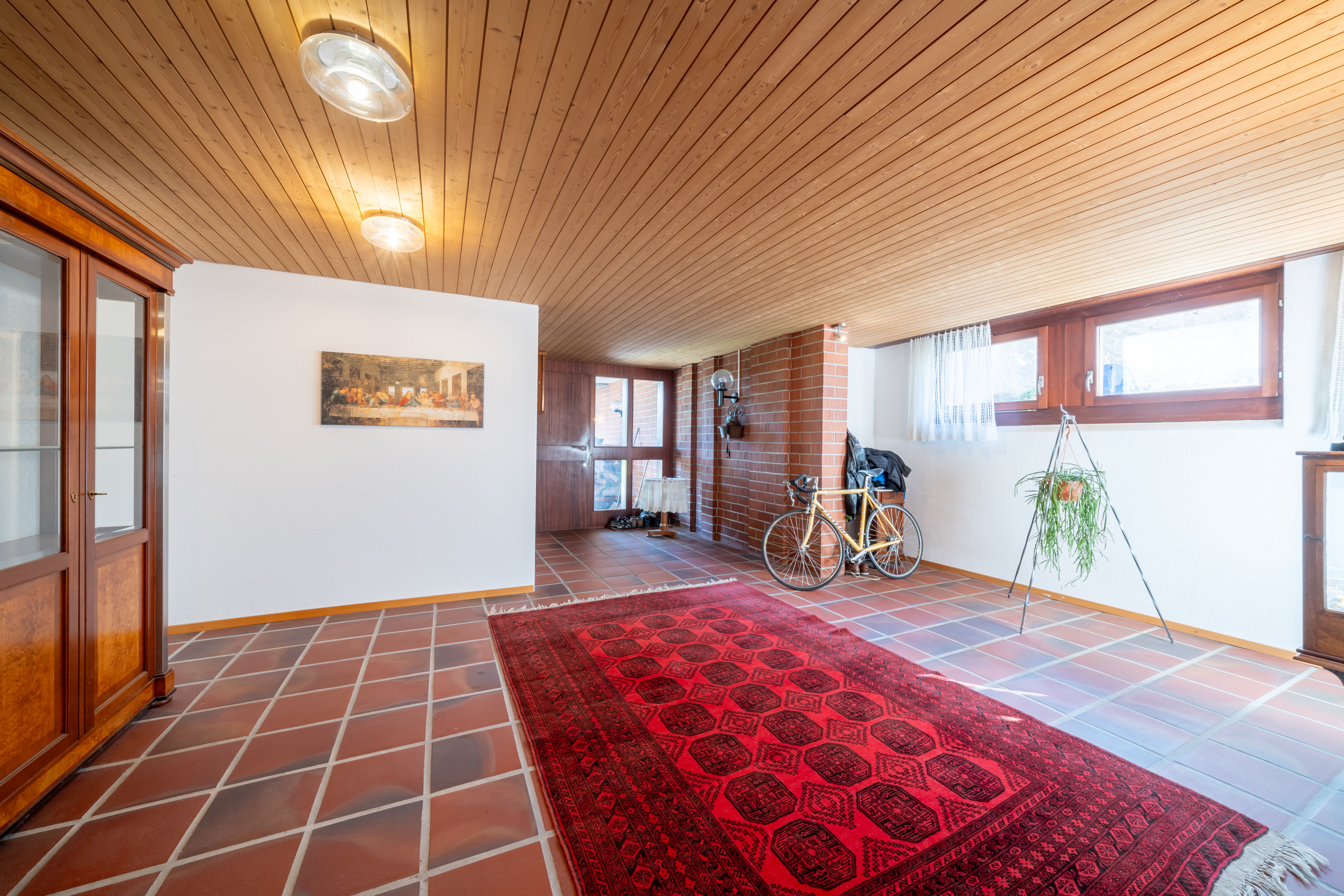 Eingangsbereich mit Klinker, Holzdecke und Fliesenboden