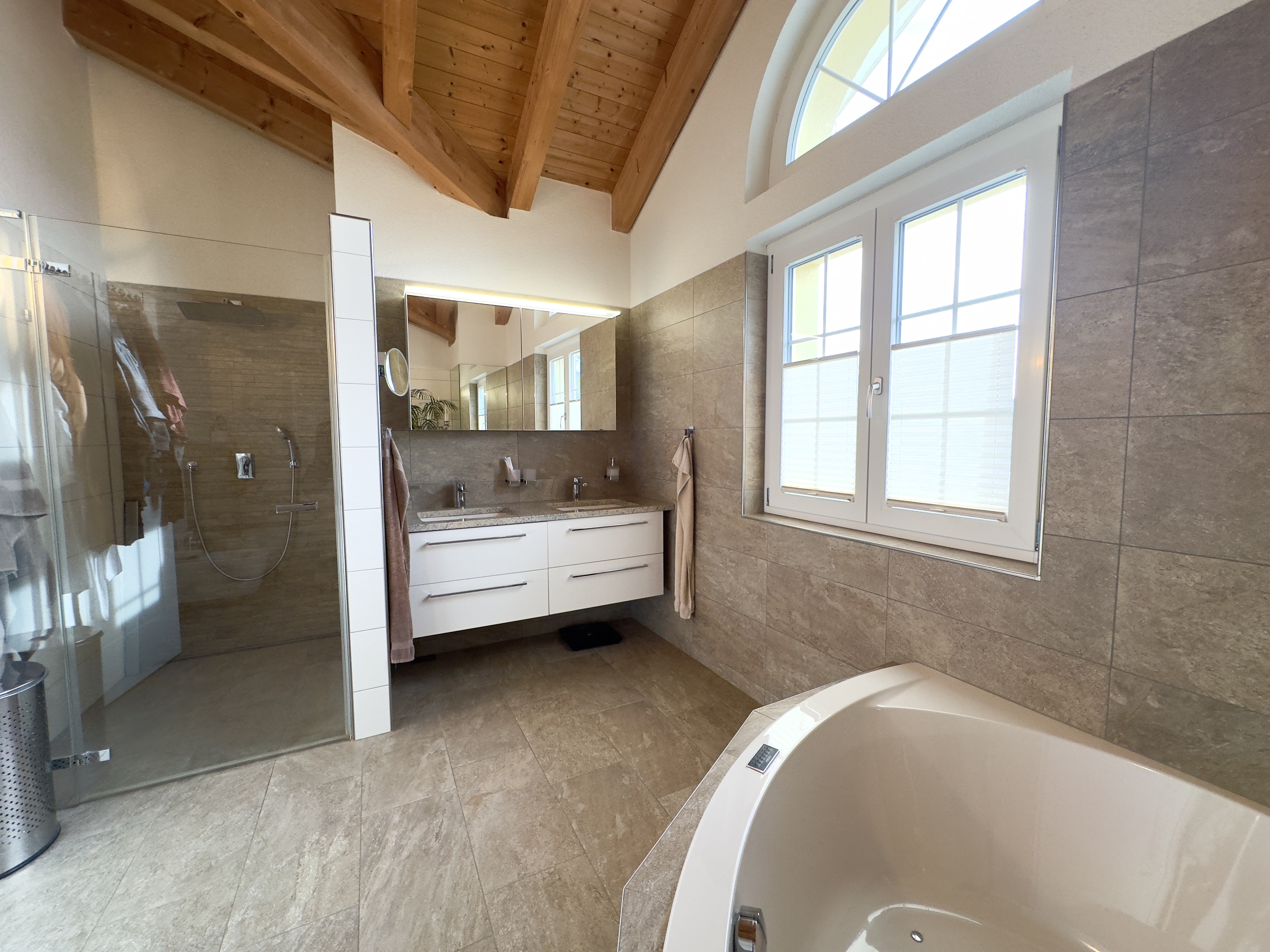 Elegantes Badezimmer mit Holzdecke und Natursteinfliesen