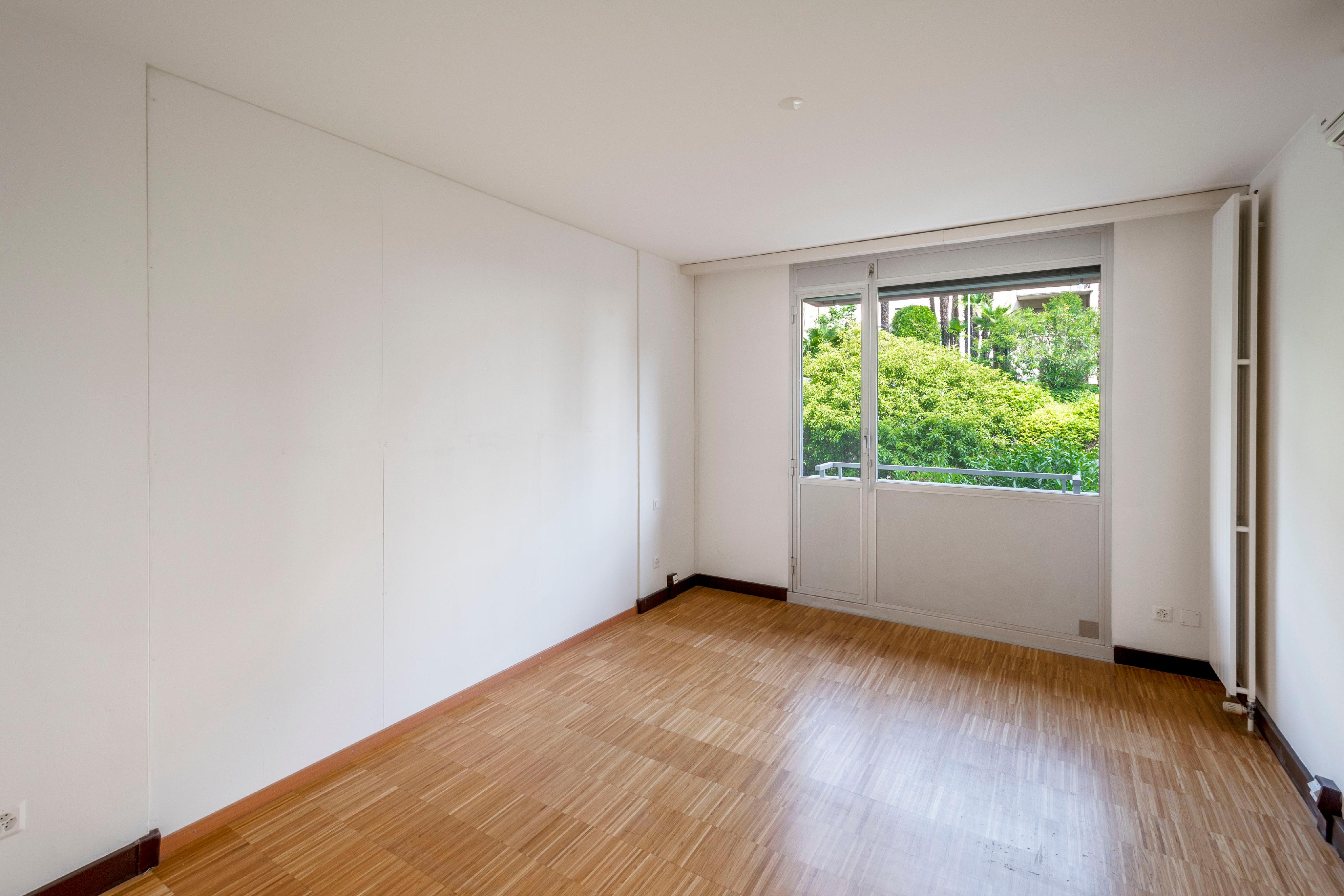 Leerer, heller Raum mit Balkon-/Fensterfront