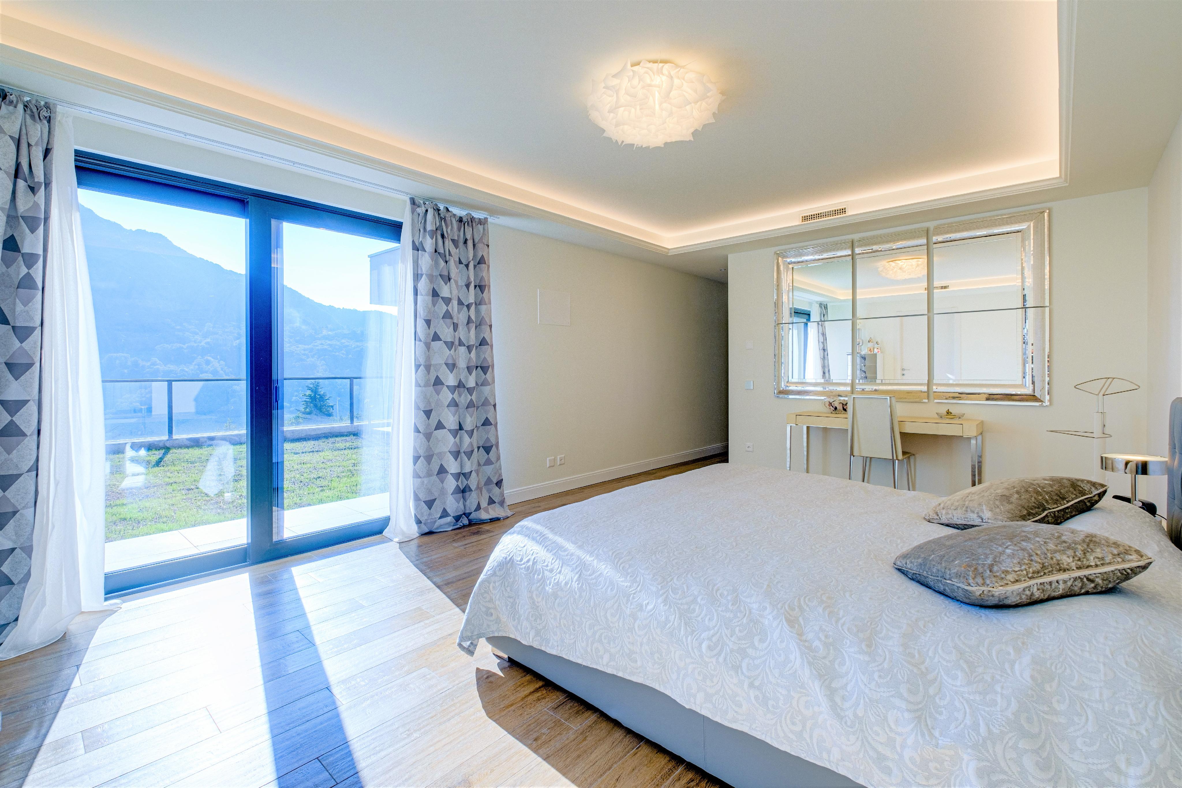 Helles Schlafzimmer mit Balkon und Bergblick