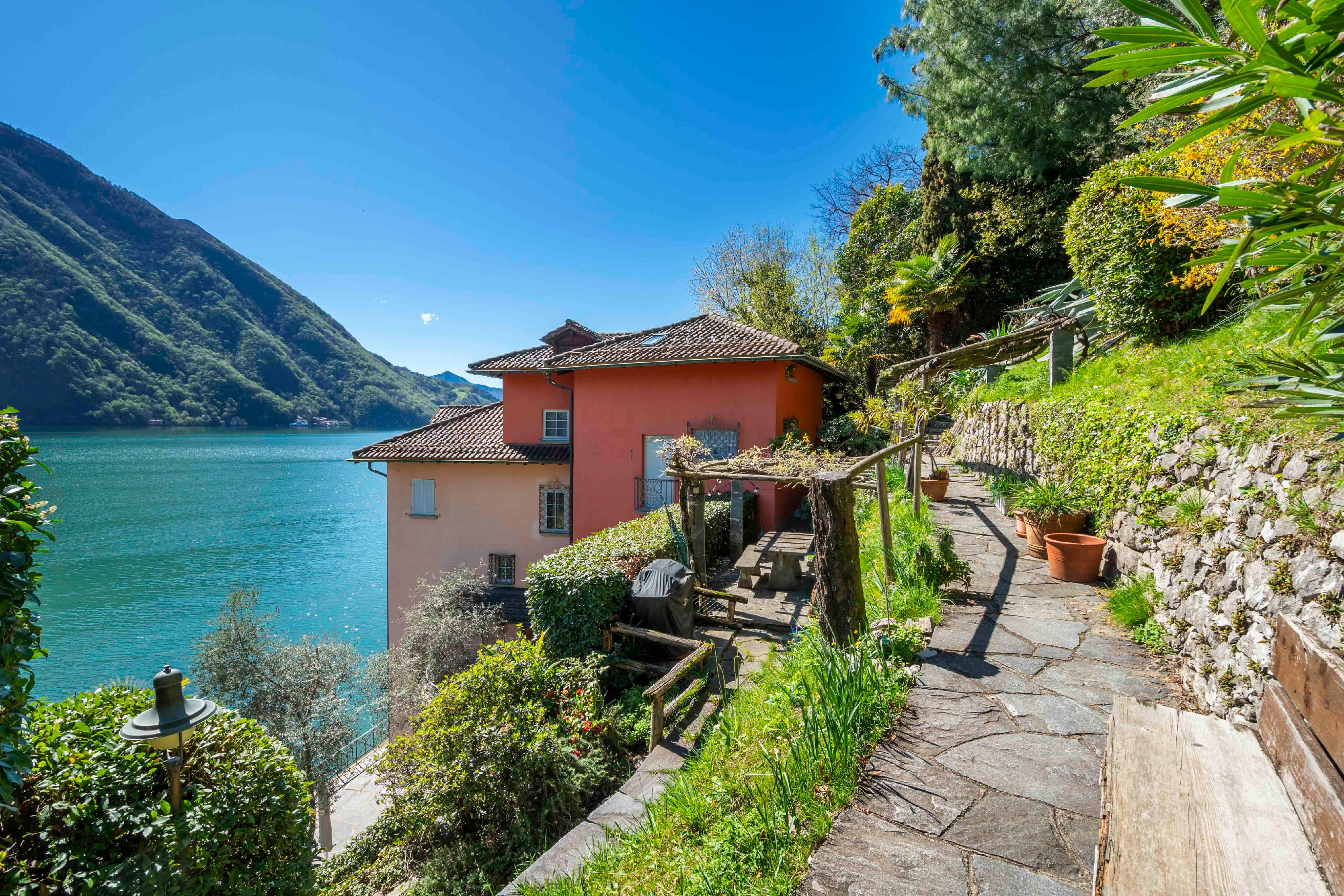Seeblick mit mediterranem Haus und Gartenweg