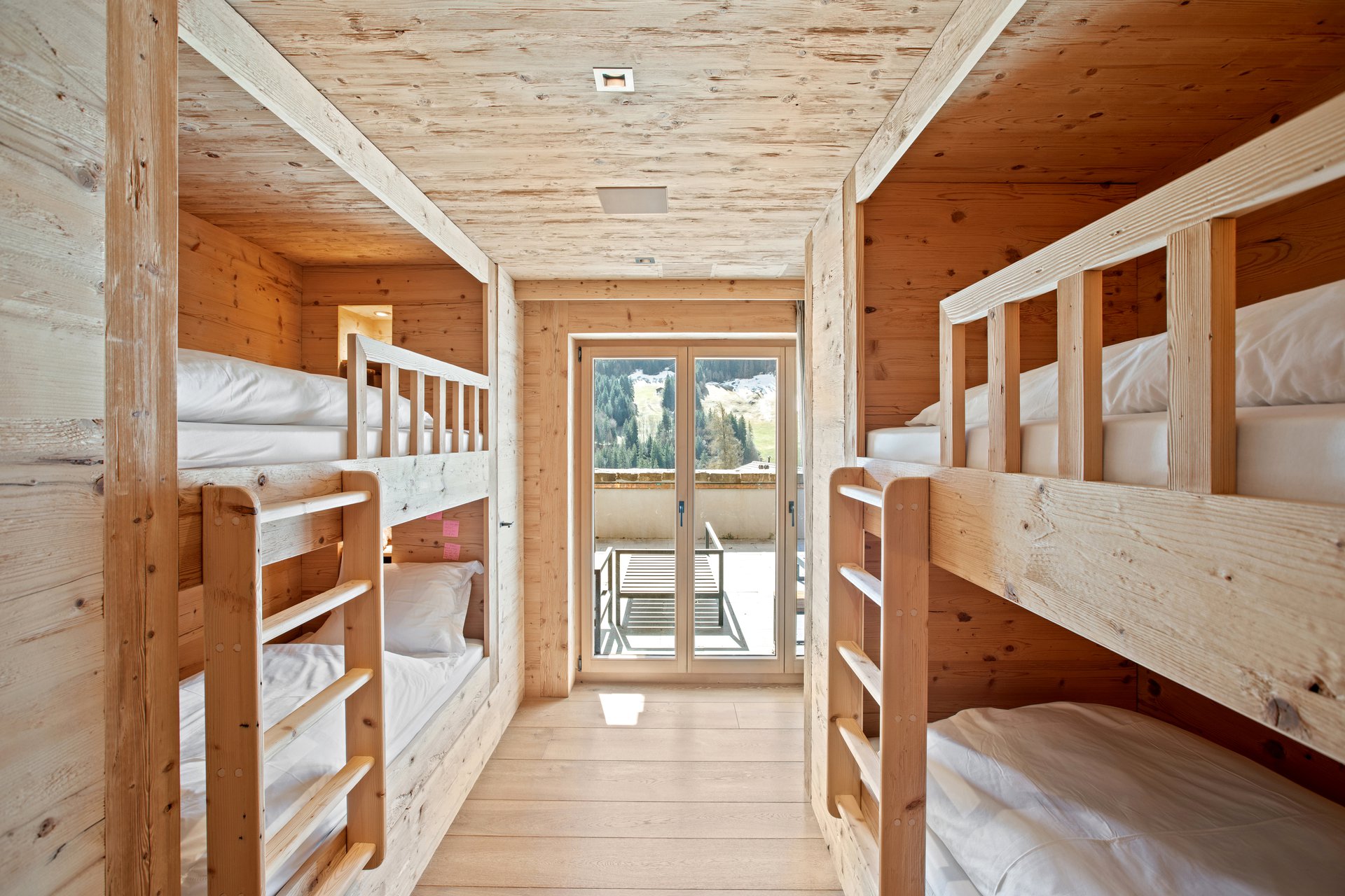 Holz-Schlafraum mit Etagenbetten und Bergblick