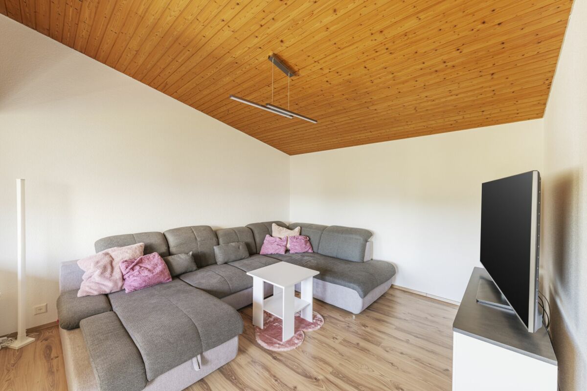Wohnzimmer mit L-förmigem Sofa und Holzdecke