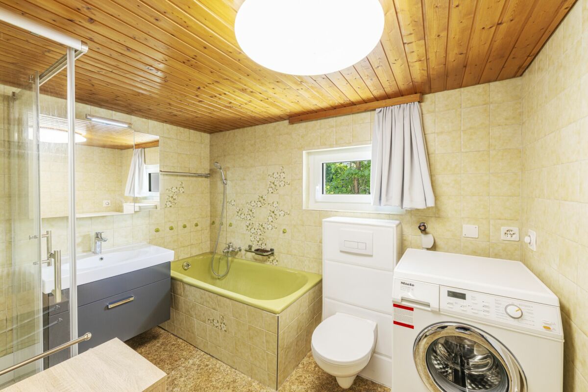 Badezimmer mit Holzdecke und Badewanne