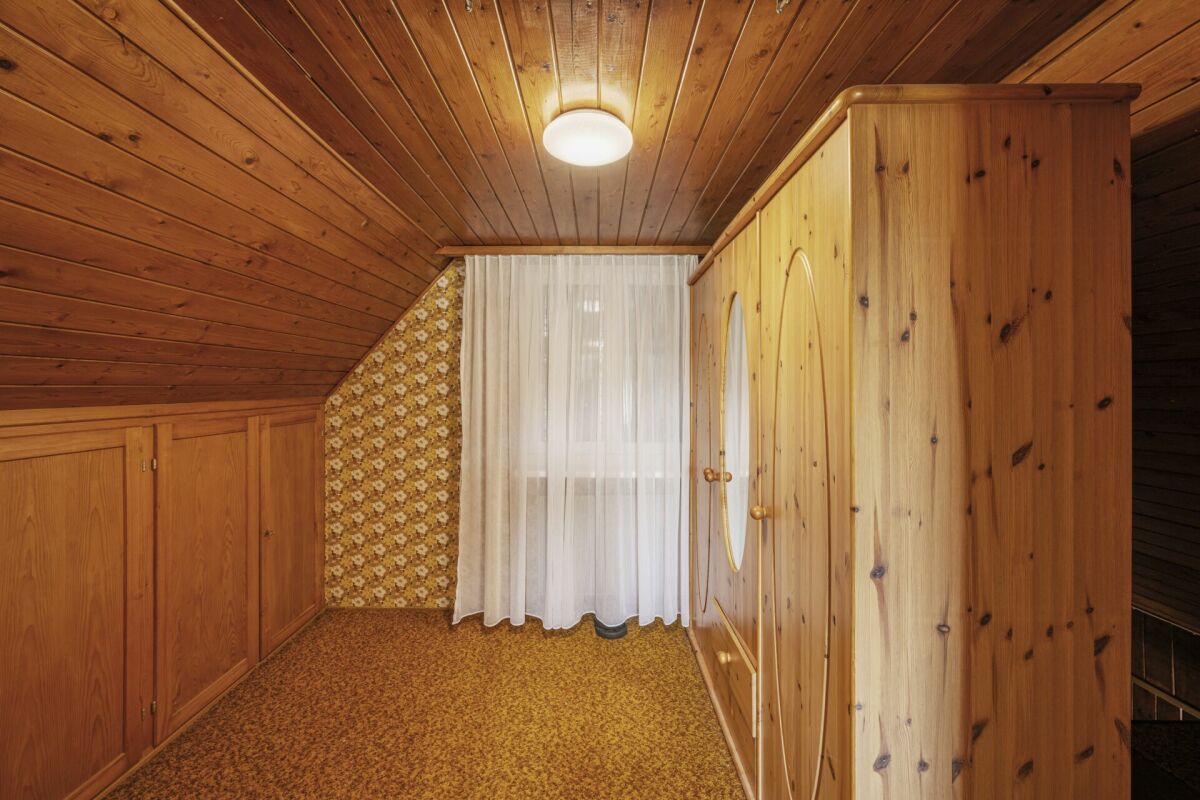 Dachzimmer mit Holzverkleidung und Einbauschrank