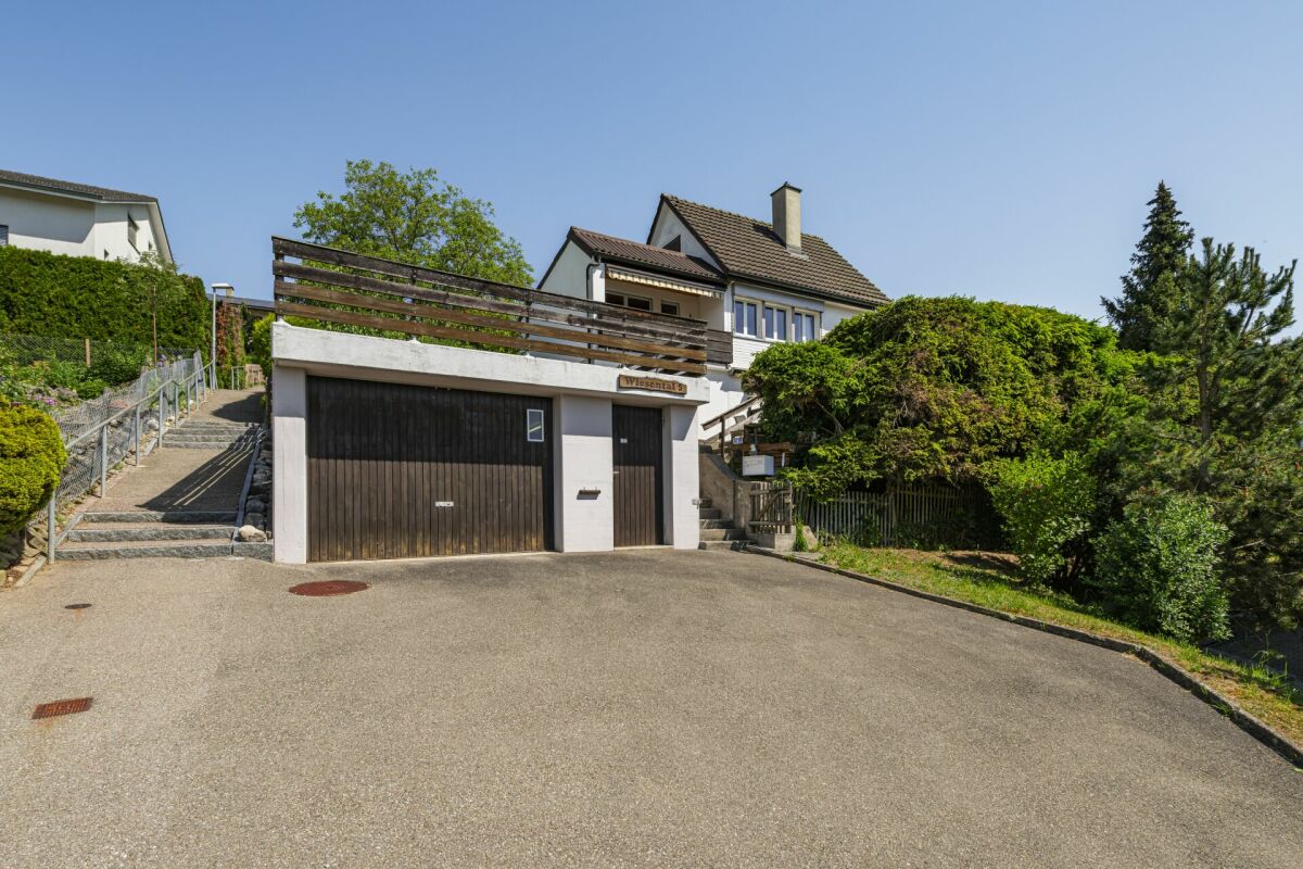 Garage mit Zufahrt und Wohnhaus