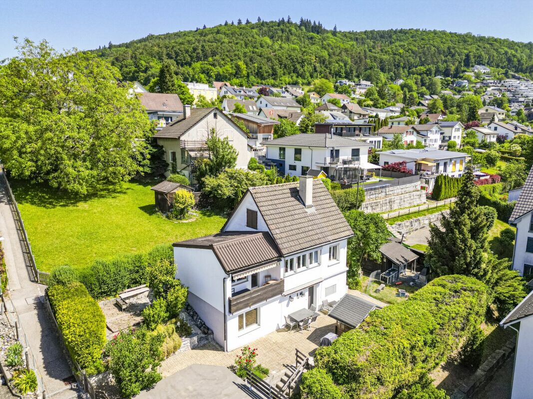 Drohnenaufnahme eines Wohnhauses mit Garten und Hanglage
