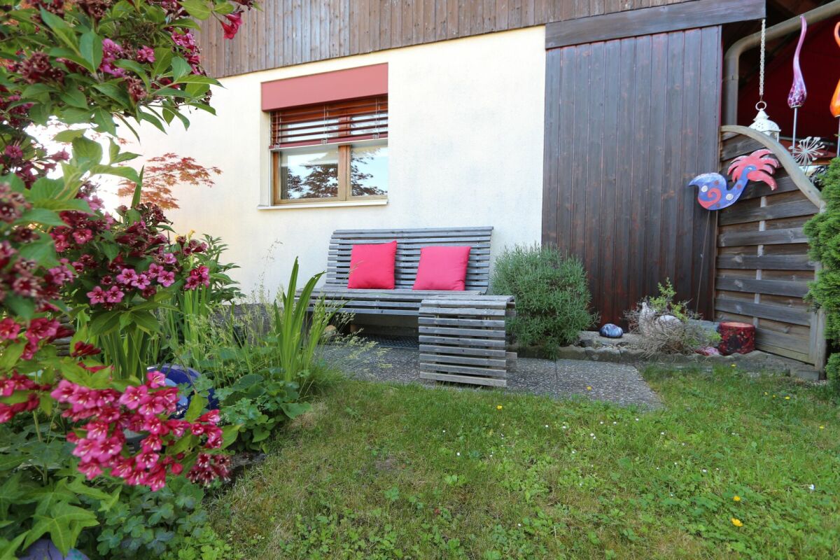 Gemütliche Gartenansicht mit Bank und Blumen