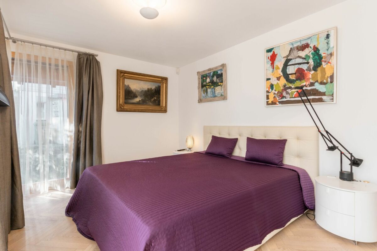 Schlafzimmer mit großem Bett und Kunstwerken