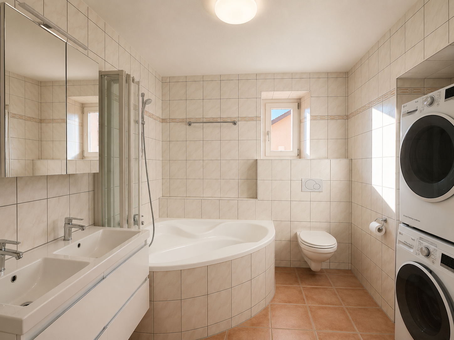 Hell gefliestes Badezimmer mit Badewanne, Doppelwaschtisch und Waschmaschine/Trockner
