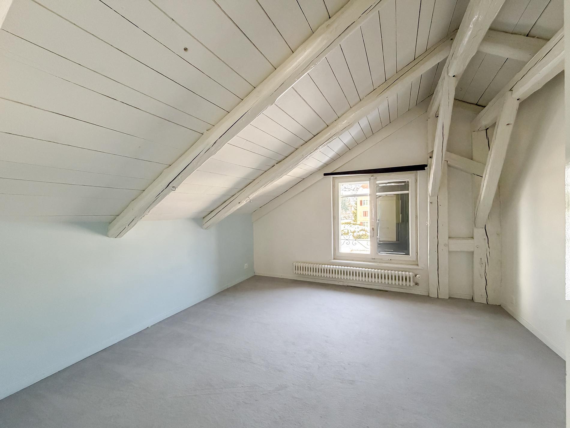 Dachgeschossraum mit sichtbaren Holzbalken