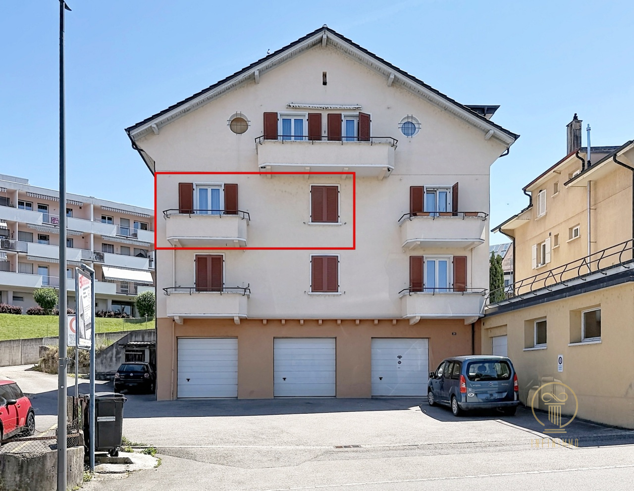 Mehrfamilienhaus mit Garagen im Straßenbild
