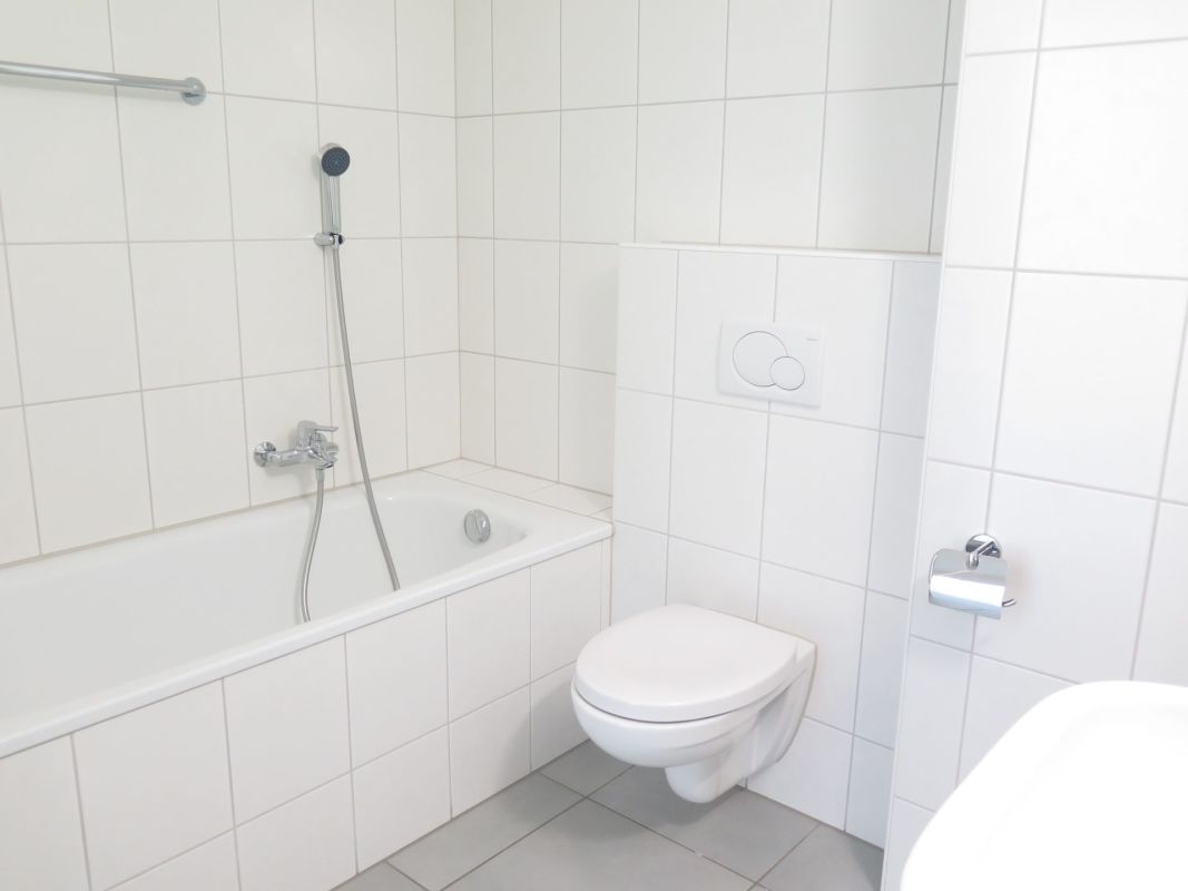 Helles Badezimmer mit Badewanne und wandhängendem WC