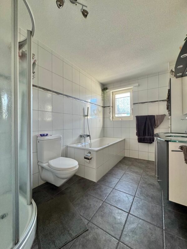 Badezimmer mit Badewanne und Duschkabine