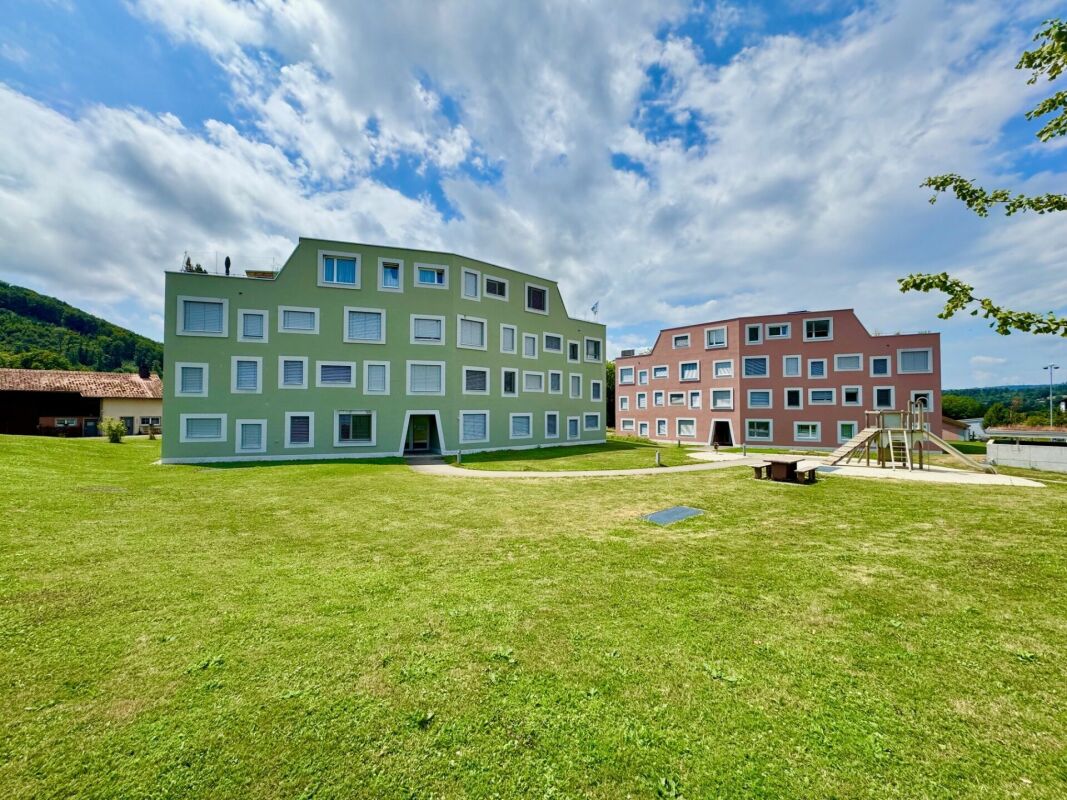 Außenansicht eines Wohngebäudekomplexes mit Grünfläche