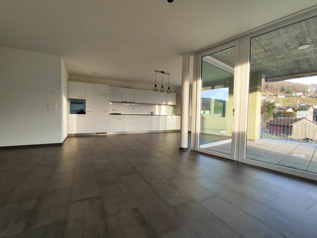 Offener Wohnbereich mit Küche und großer Terrassentür