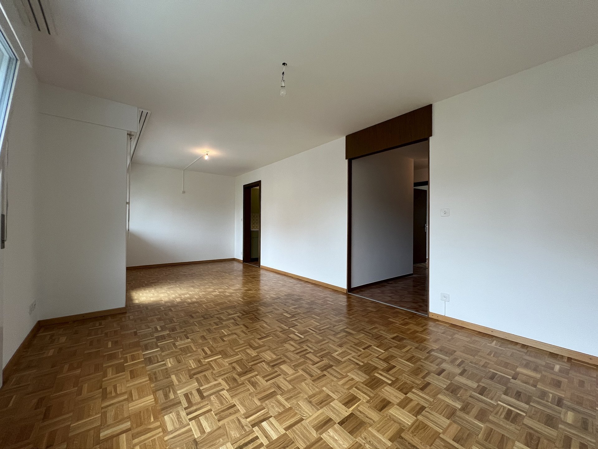 Leerer Wohnraum mit Parkettboden