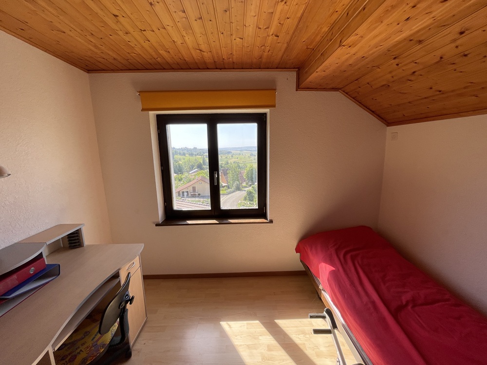 Helles kleines Dachzimmer mit Schreibtisch und Einzelbett