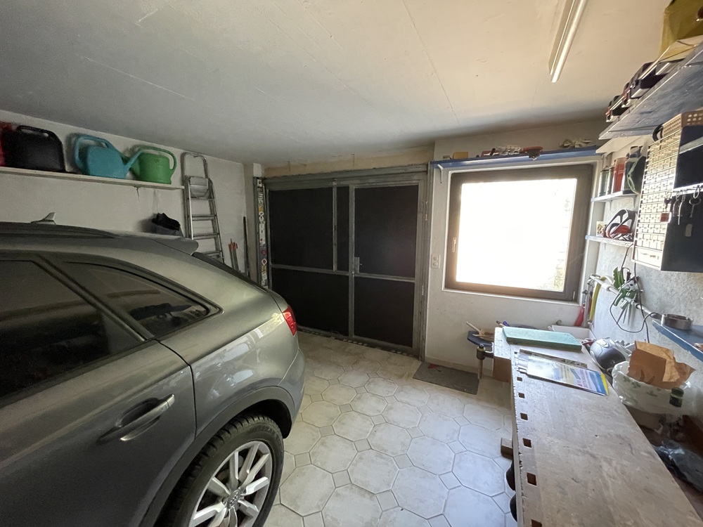 Garage mit geparktem Auto und Arbeitsbereich