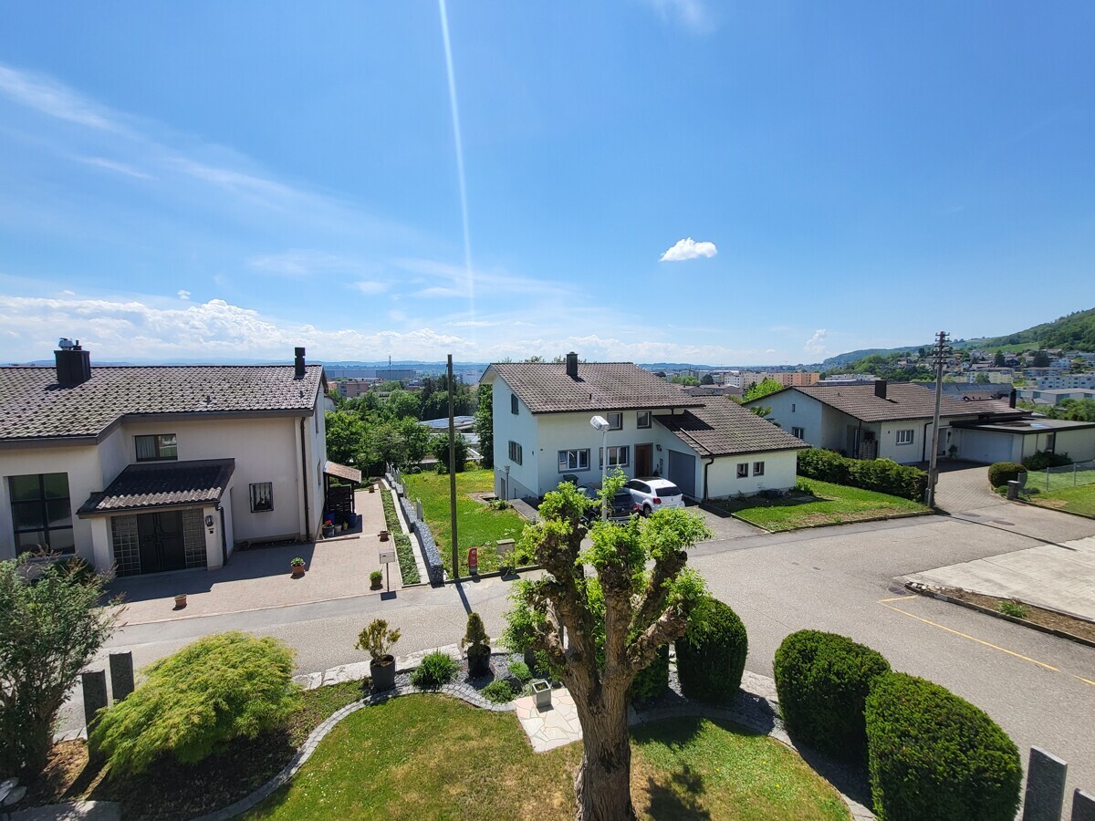 Wohnstraße mit Einfamilienhäusern und Fernblick
