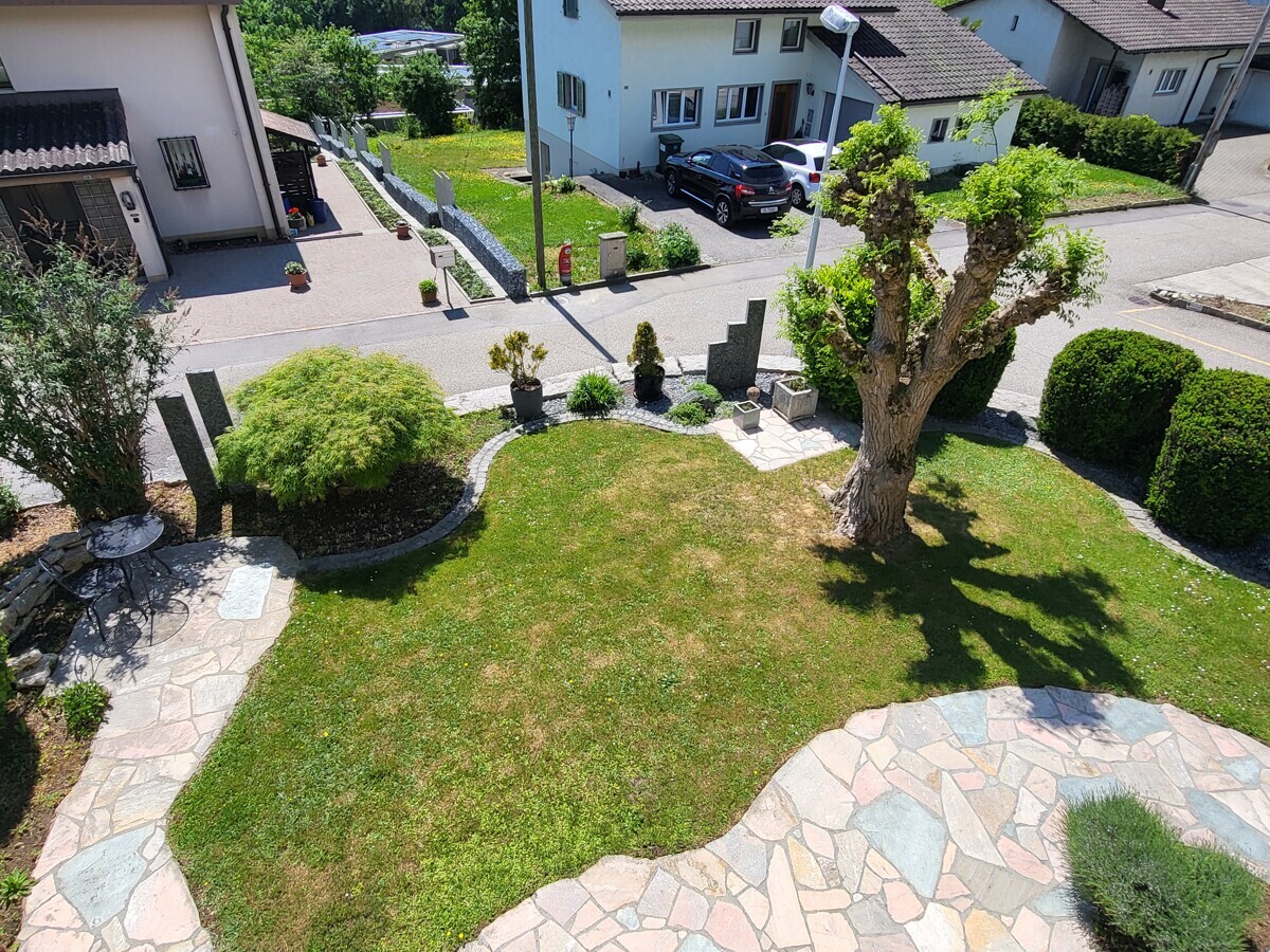 Gepflegter Vorgarten mit Terrasse und Wohnhäusern
