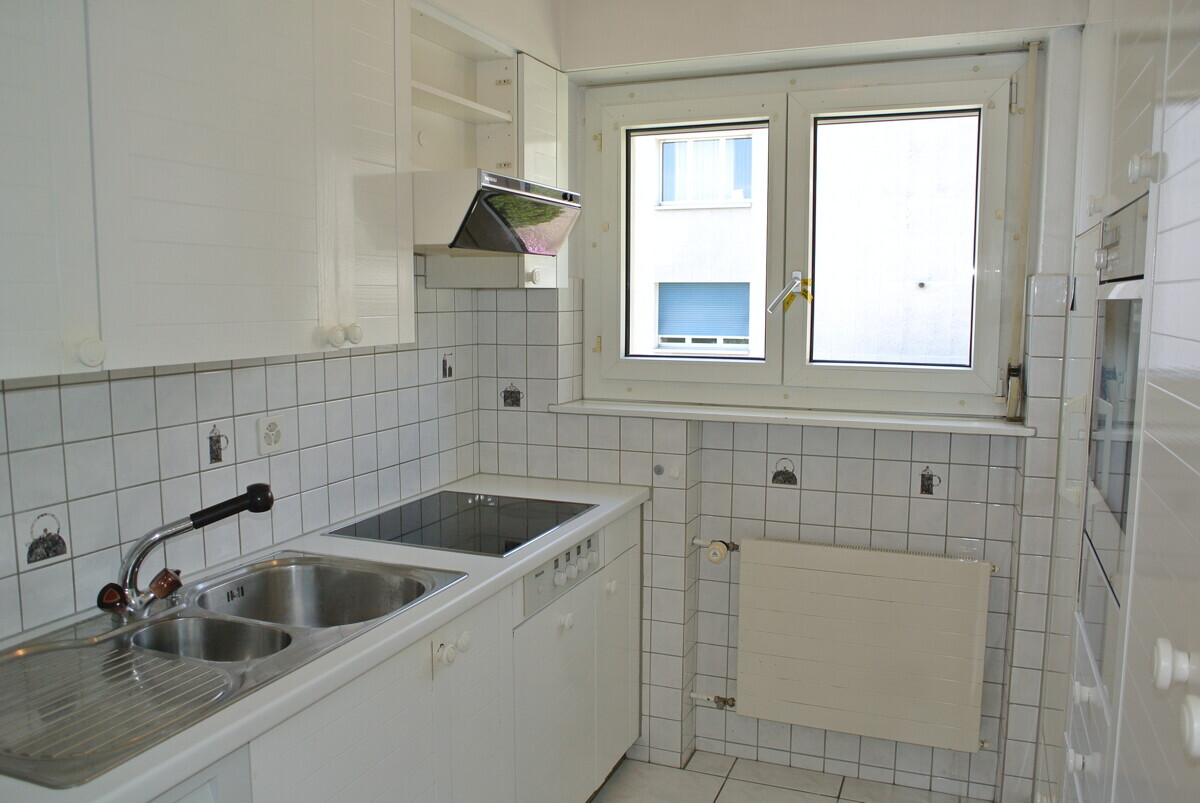 Kompakte weiße Küche mit Fenster
