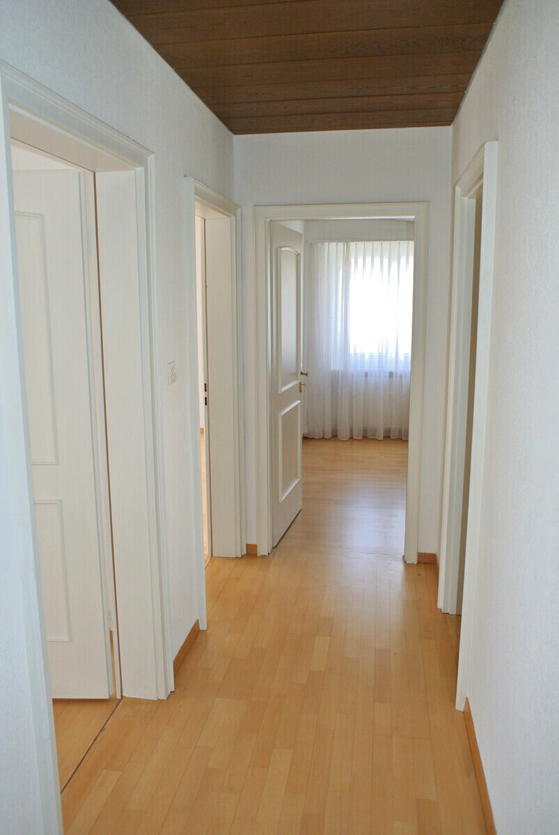 Heller Flur mit Holzboden und mehreren Türen