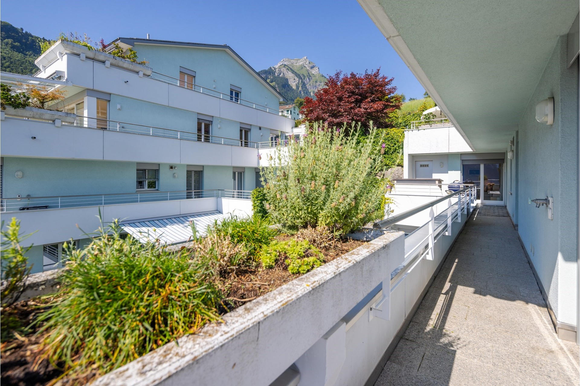 Balkon mit Blick auf Wohnanlage und Berge