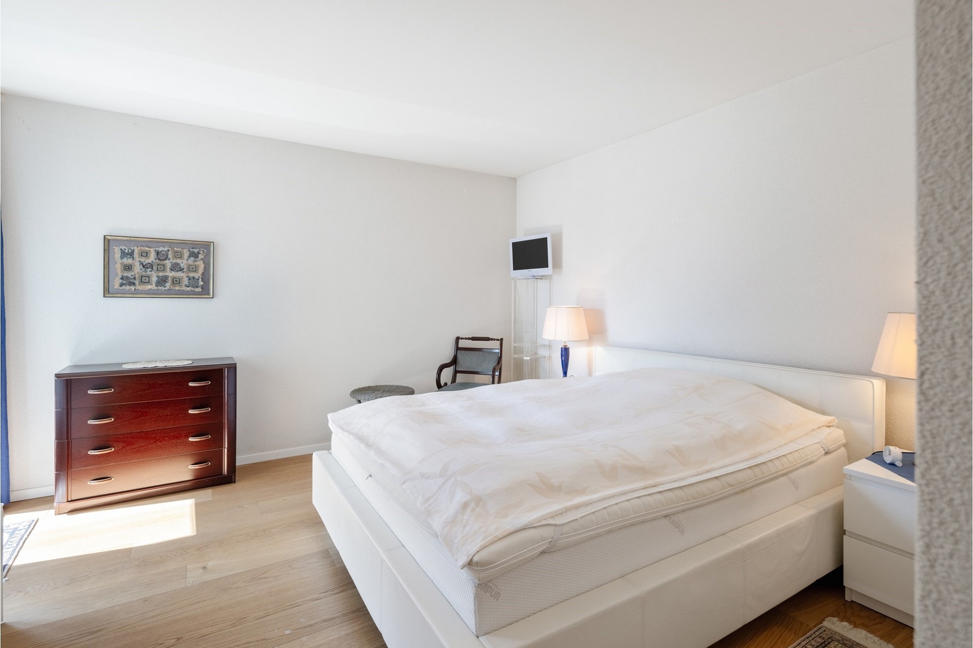 Helles Schlafzimmer mit Doppelbett und schlichtem Mobiliar