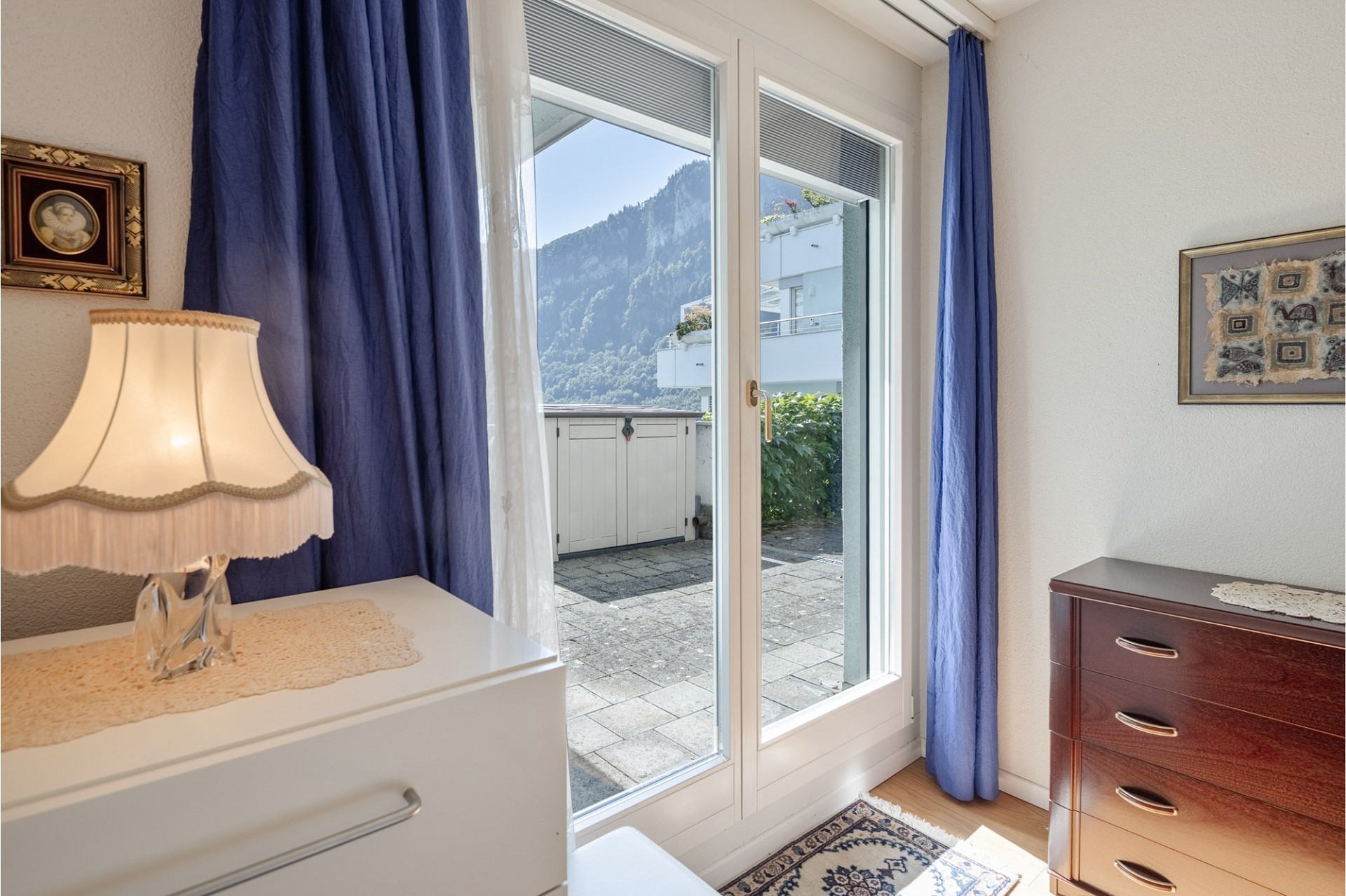 Helles Schlafzimmer mit Balkon- bzw. Terrassentür und Bergblick
