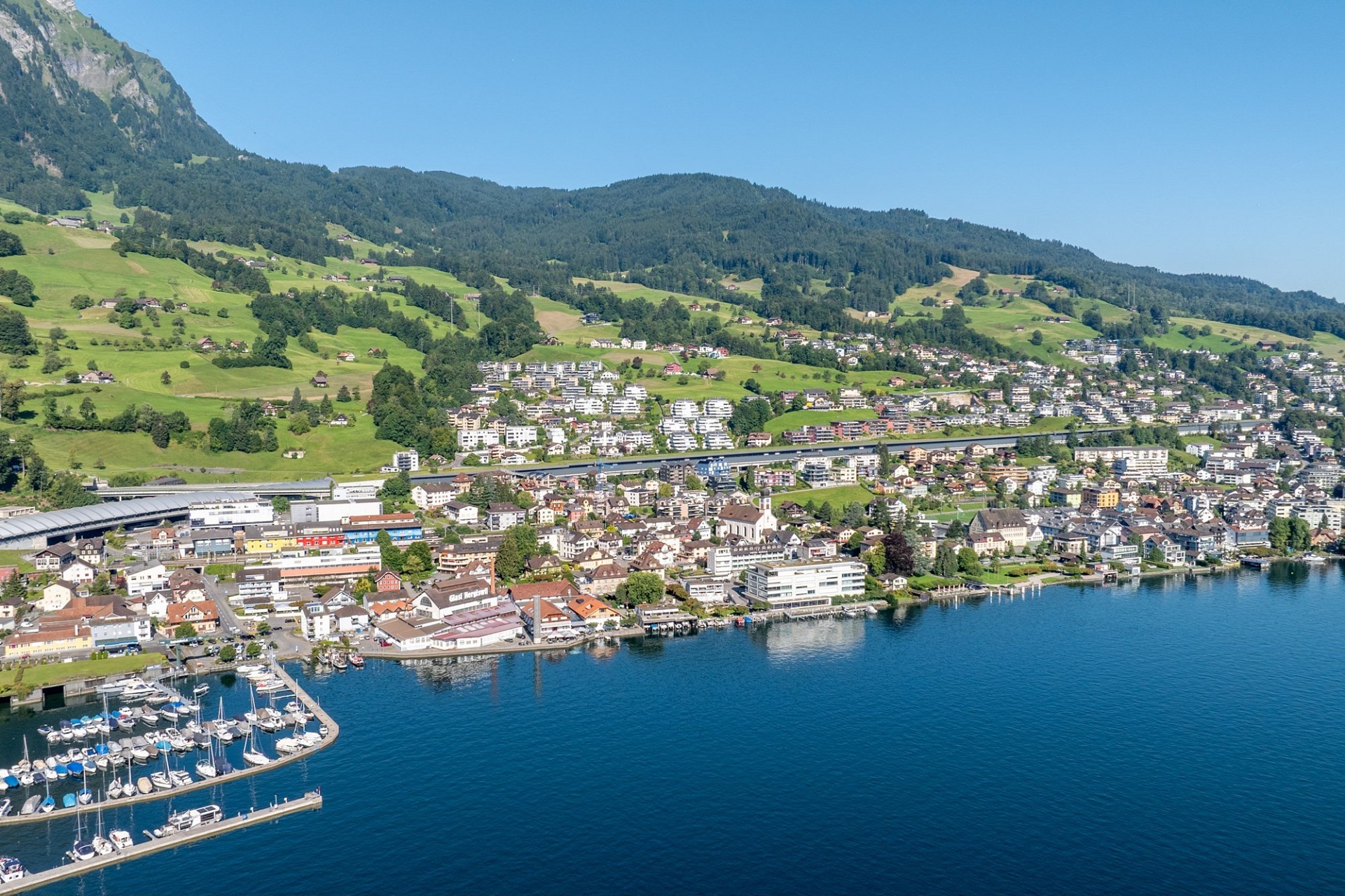 Luftaufnahme einer alpinen Seestadt mit Yachthafen