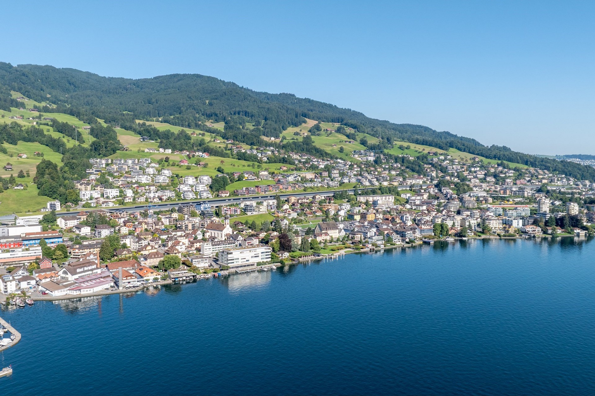 Luftaufnahme einer Seeuferstadt mit Bergen