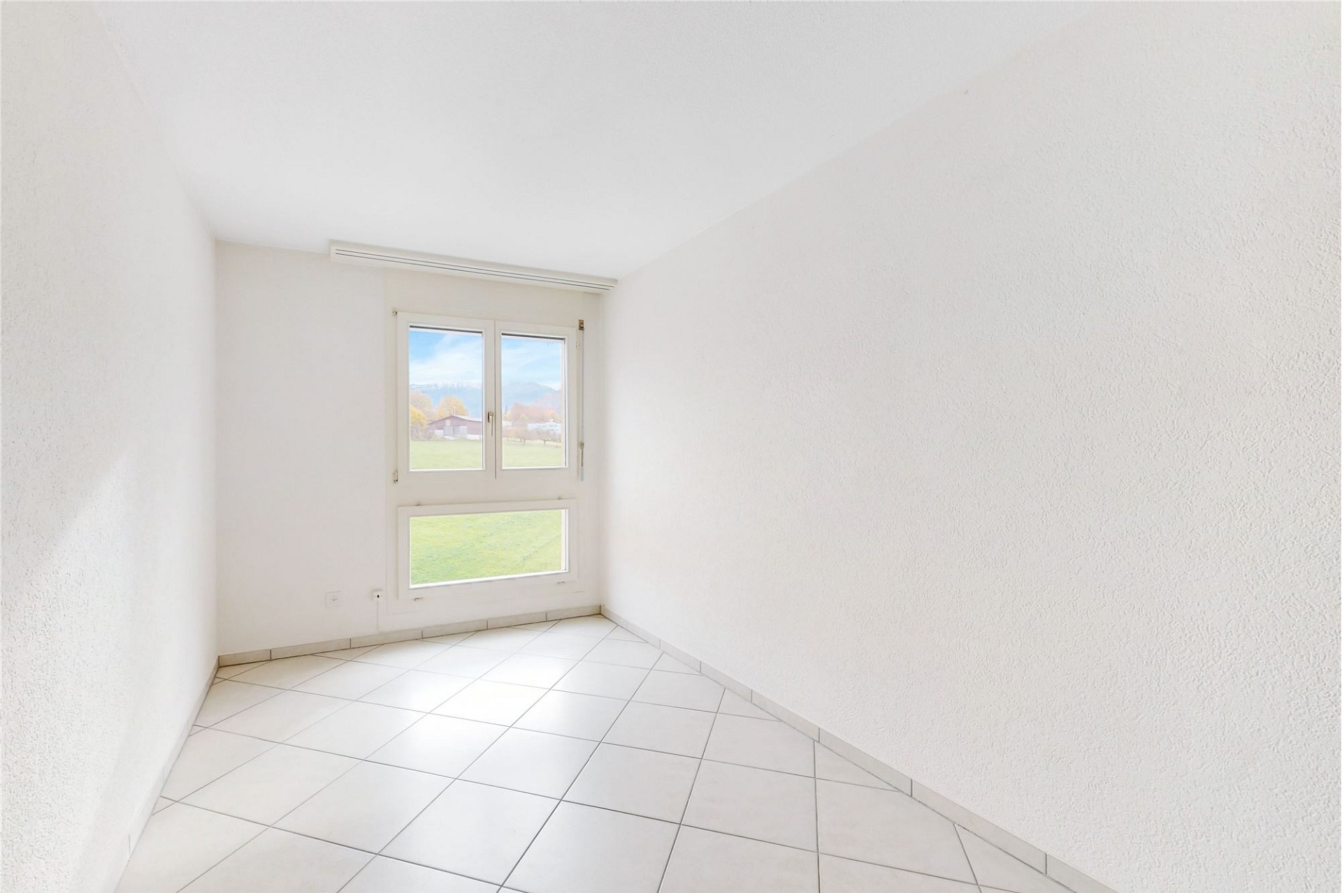 Heller leerer Raum mit Fenster und Fliesenboden