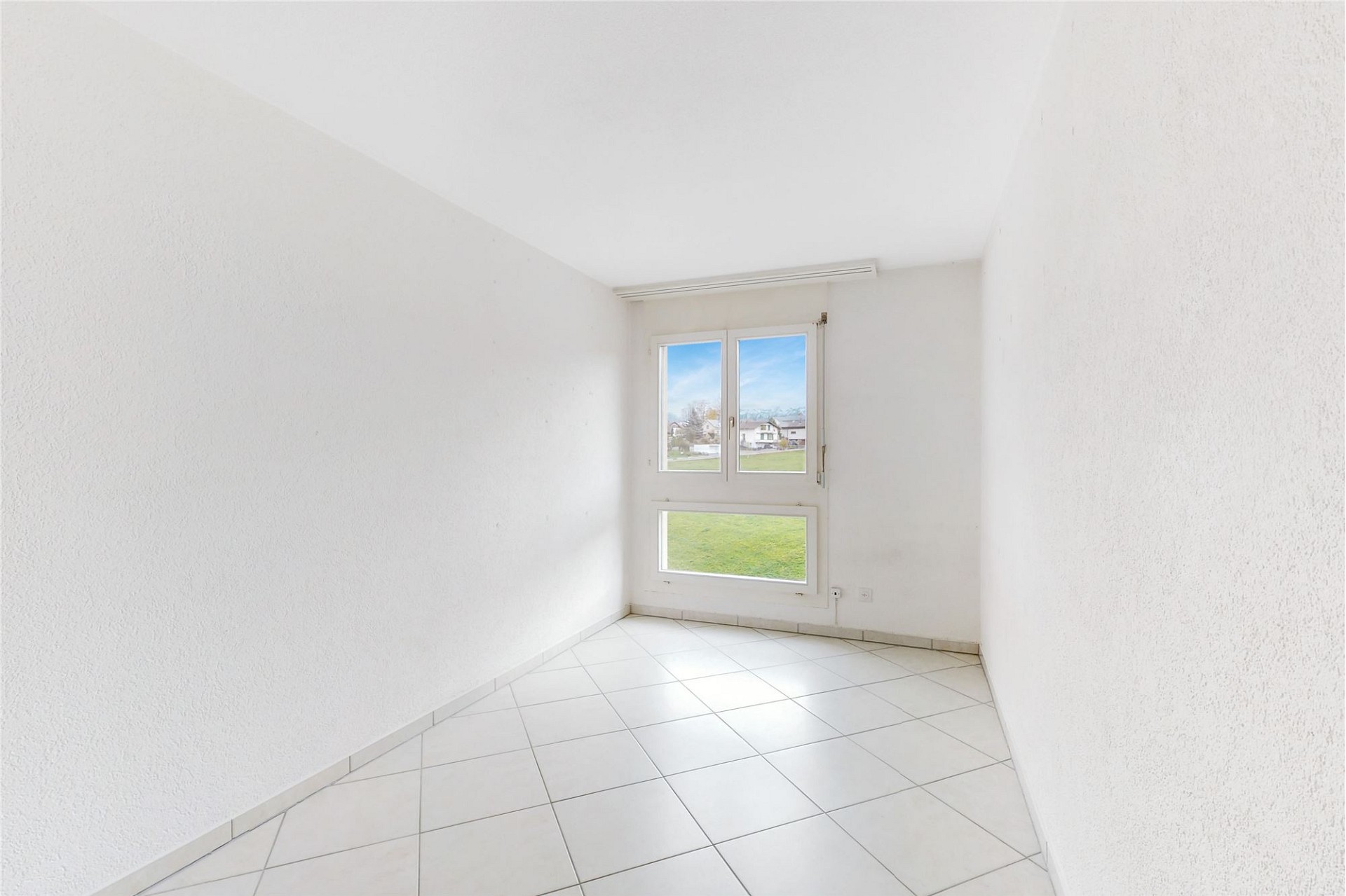 Helles, leeres Zimmer mit großem Fenster