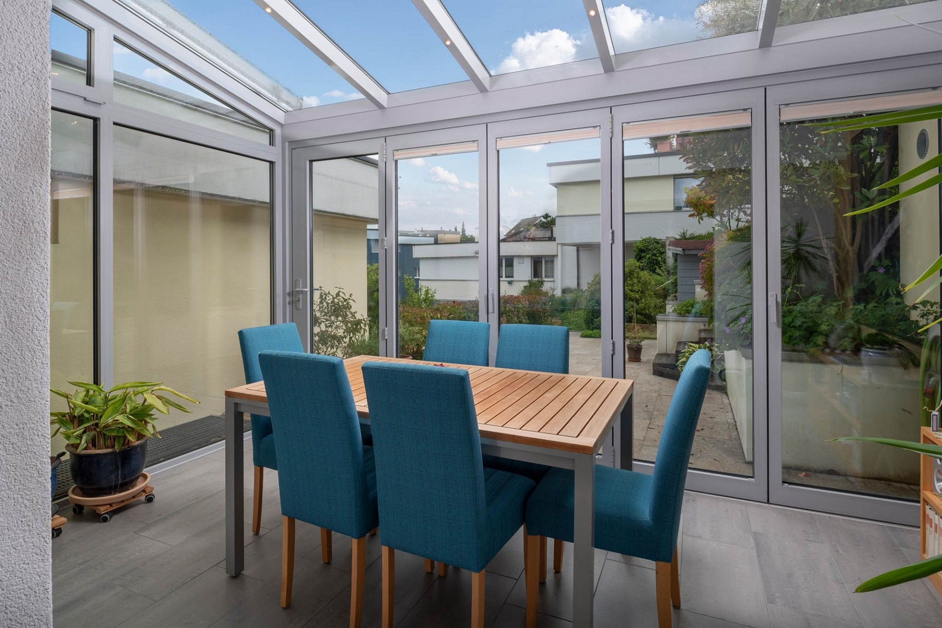 Verglaster Essbereich mit Terrassenmöbeln